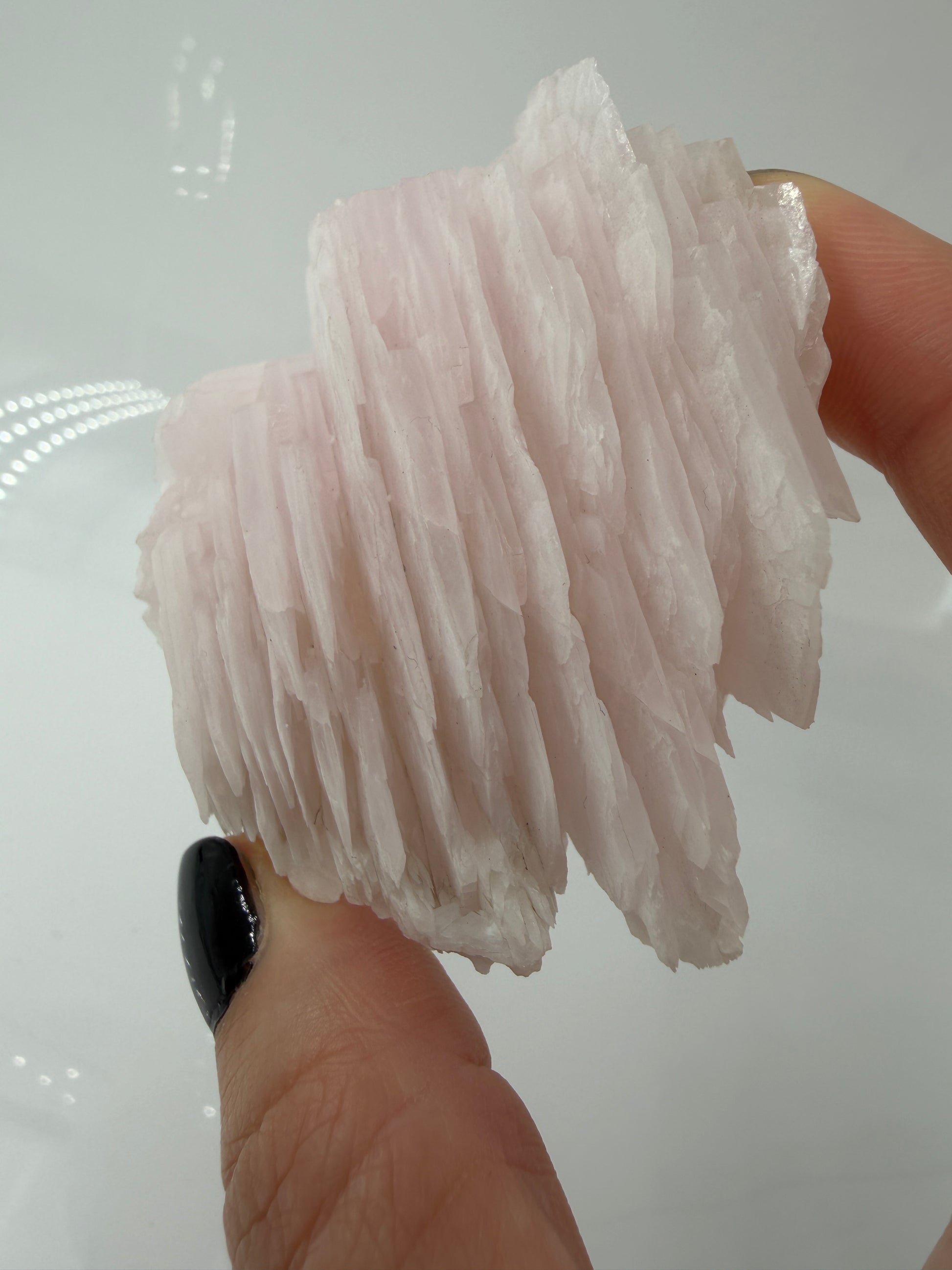 Naturbelassener Rohstein aus Mangano-Calcit in zartem Rosa mit sichtbaren Spaltflächen.