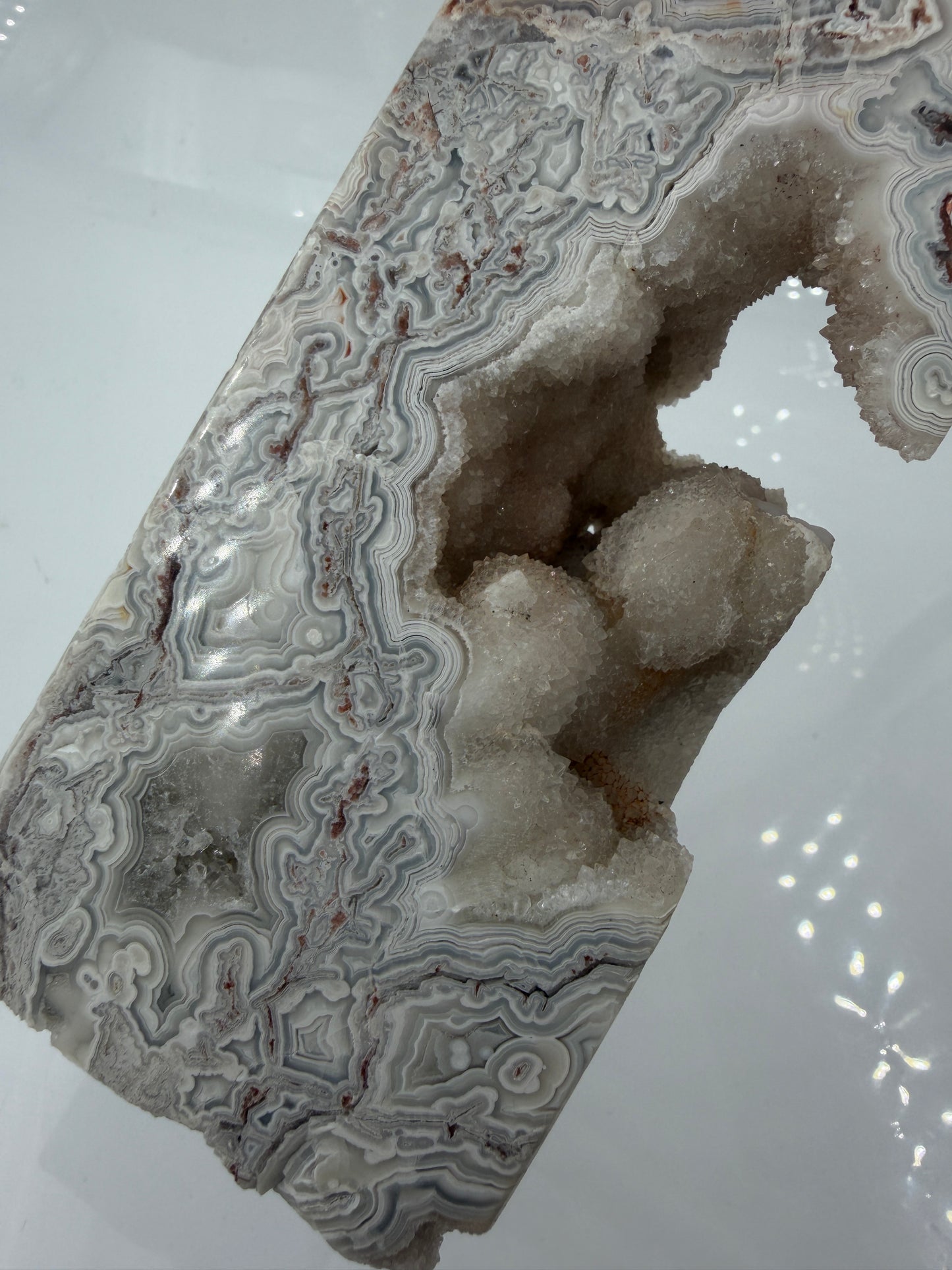 Spitze aus Mexican Lace Achat, 25 x 6 cm – konzentrische Bänderung in Rot, Orange, Creme und Grau, polierte Oberfläche mit natürlicher Spitzenform.