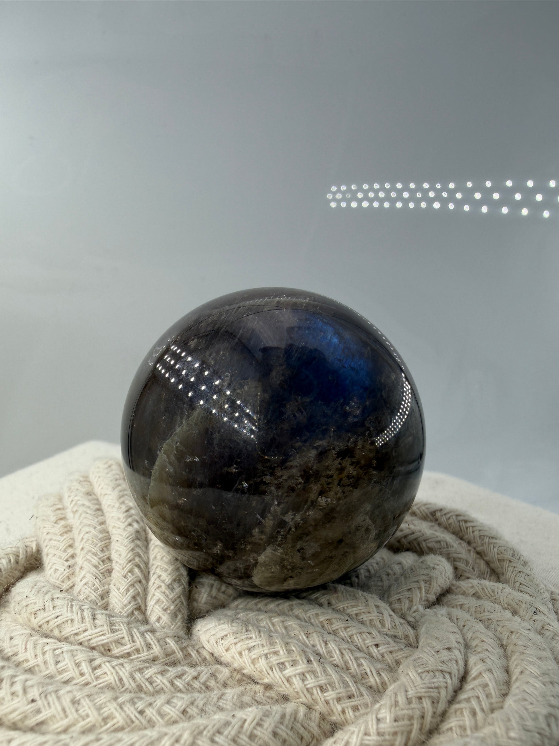 Sphärisch geschliffene dunkle Mondstein Kugel mit ausgeprägtem blauen Flächenschiller (Adulareszenz) auf anthrazitfarbener Feldspat-Matrix, professionelle Sammlerqualität                       