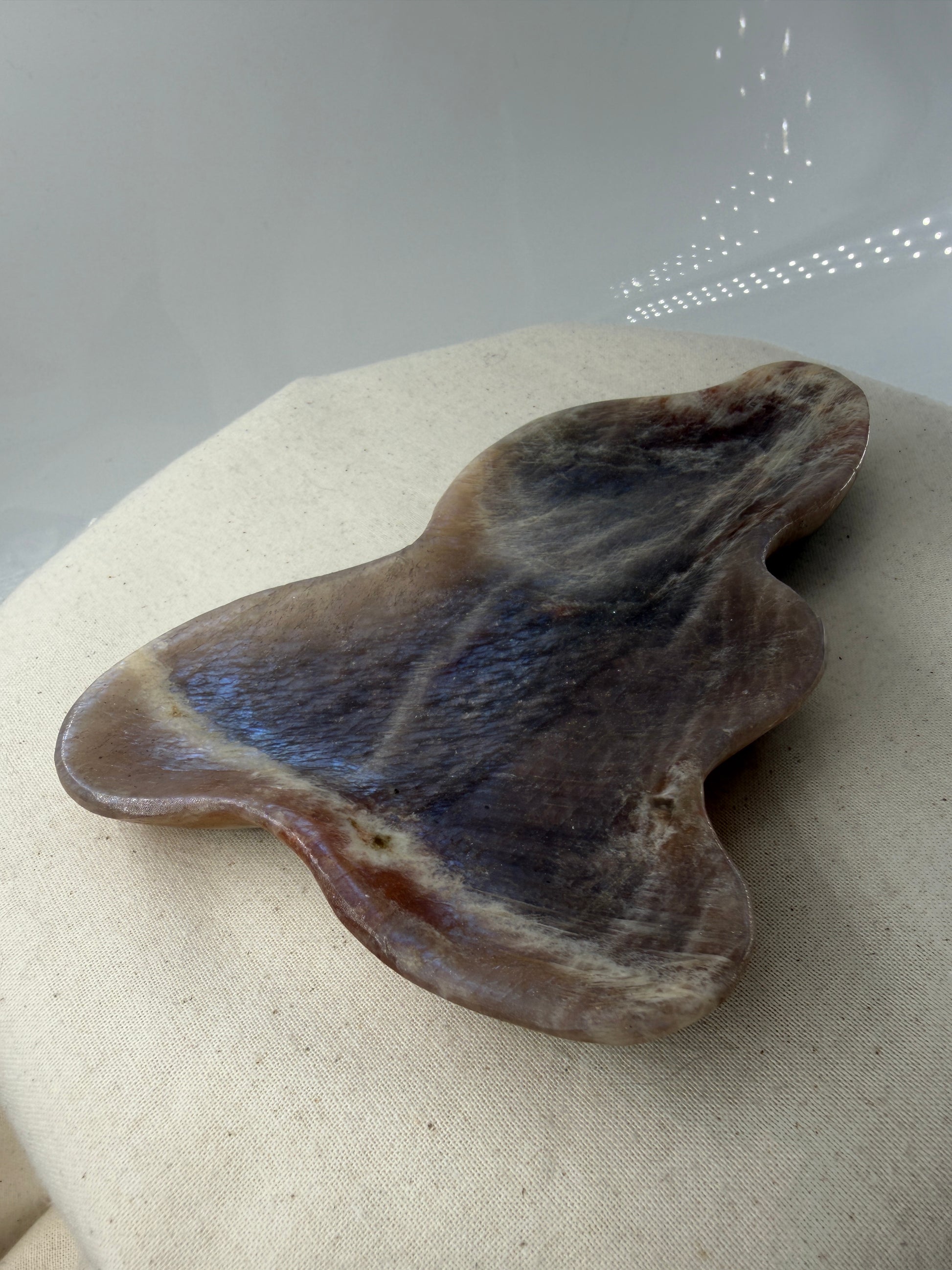 Polierte Schale aus weißem Mondstein mit charakteristischem bläulichem Schimmer (Adulareszenz).