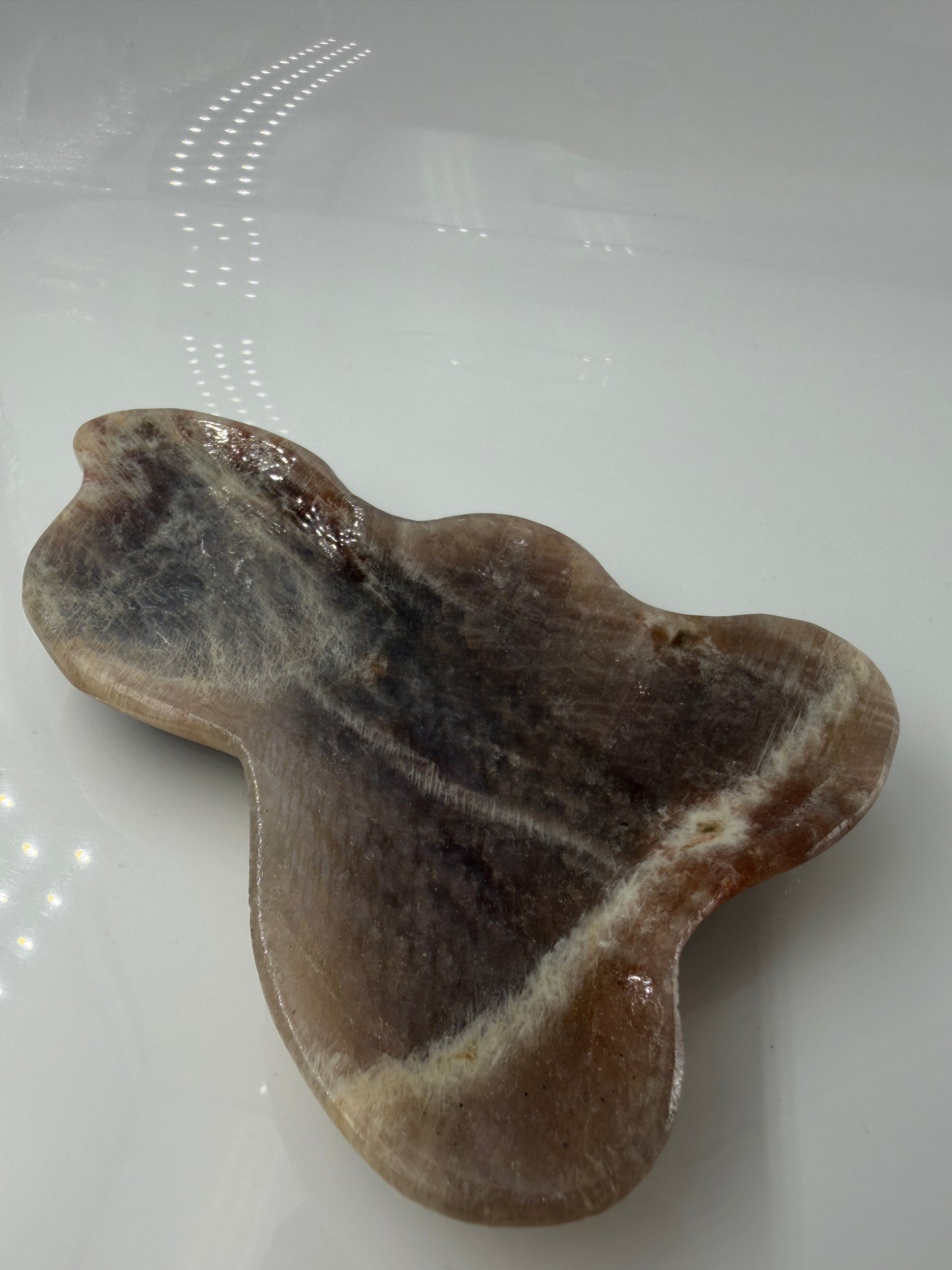Polierte Schale aus weißem Mondstein mit charakteristischem bläulichem Schimmer (Adulareszenz).