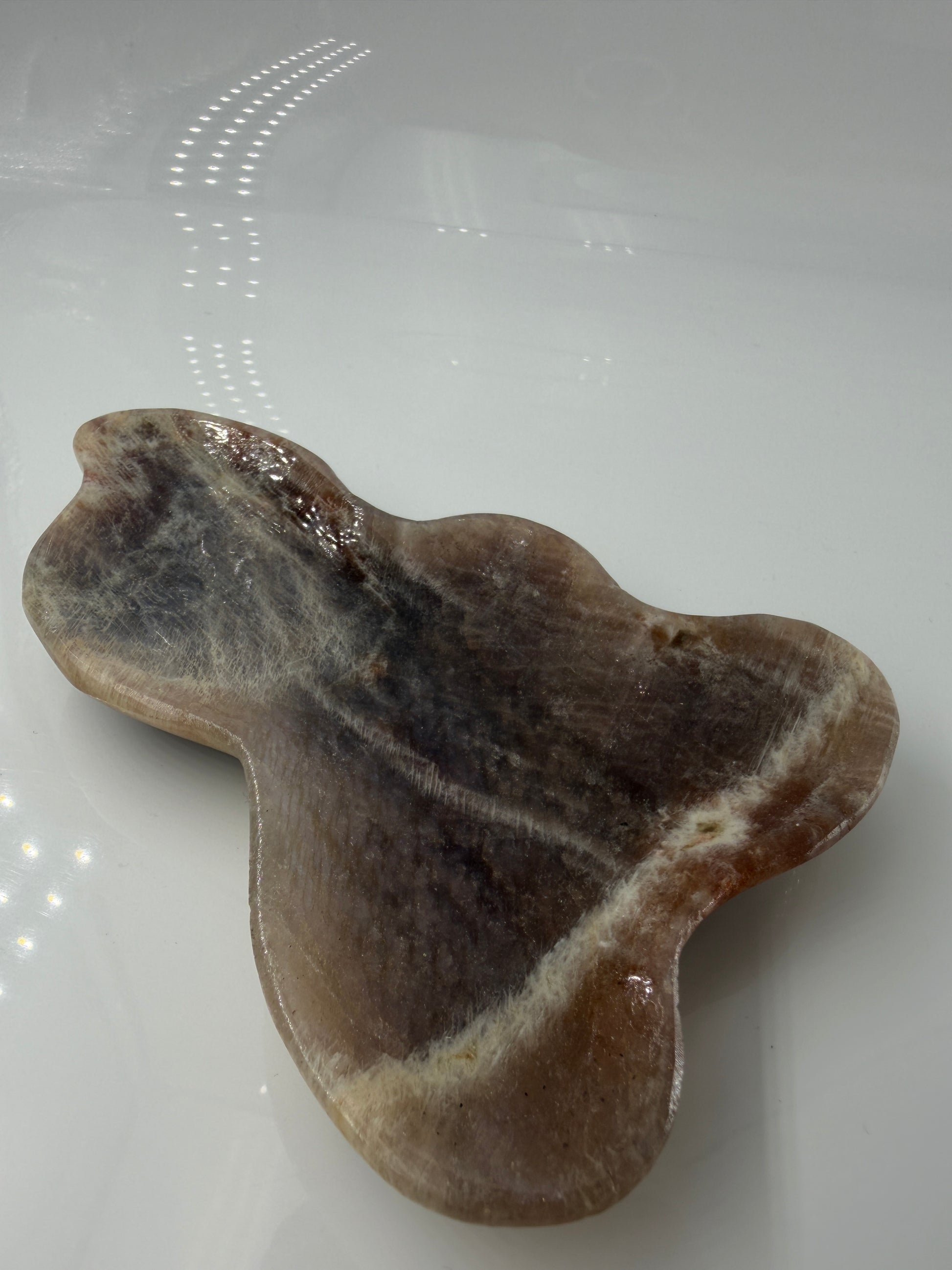 Polierte Schale aus weißem Mondstein mit charakteristischem bläulichem Schimmer (Adulareszenz).