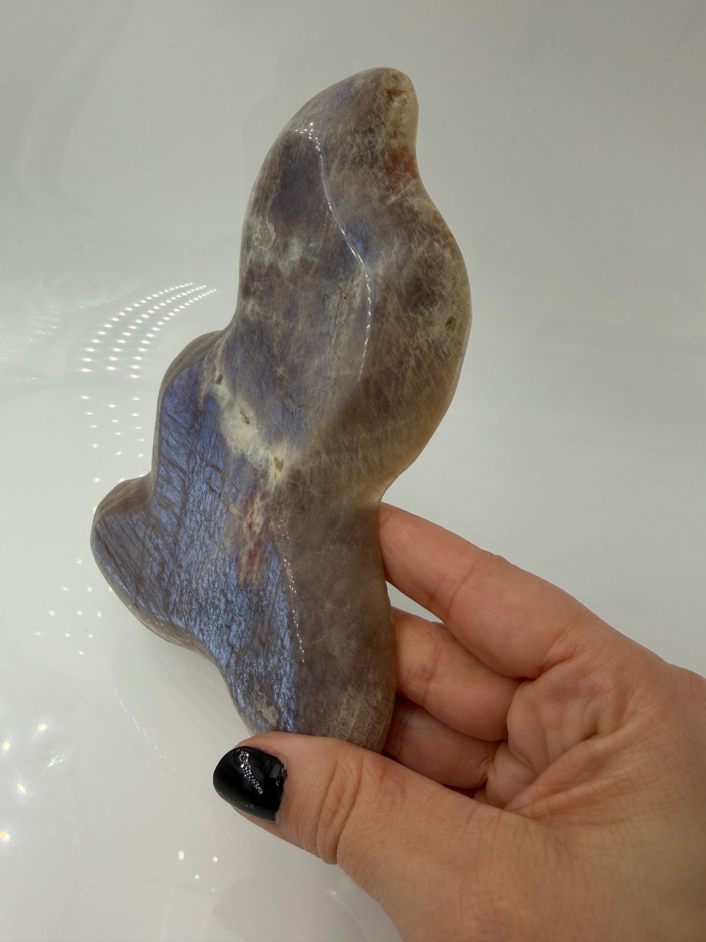Polierte Schale aus weißem Mondstein mit charakteristischem bläulichem Schimmer (Adulareszenz).