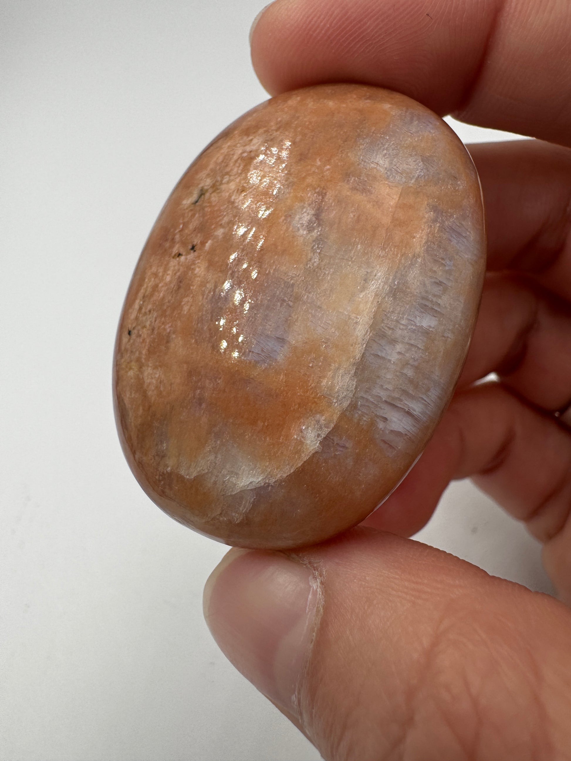 Polierter Scheibenstein aus Mondstein, 3,9 x 2,7 cm – transparentes Mineral mit sanftem blauem Adulareszenz-Schimmer auf glatter Oberfläche.