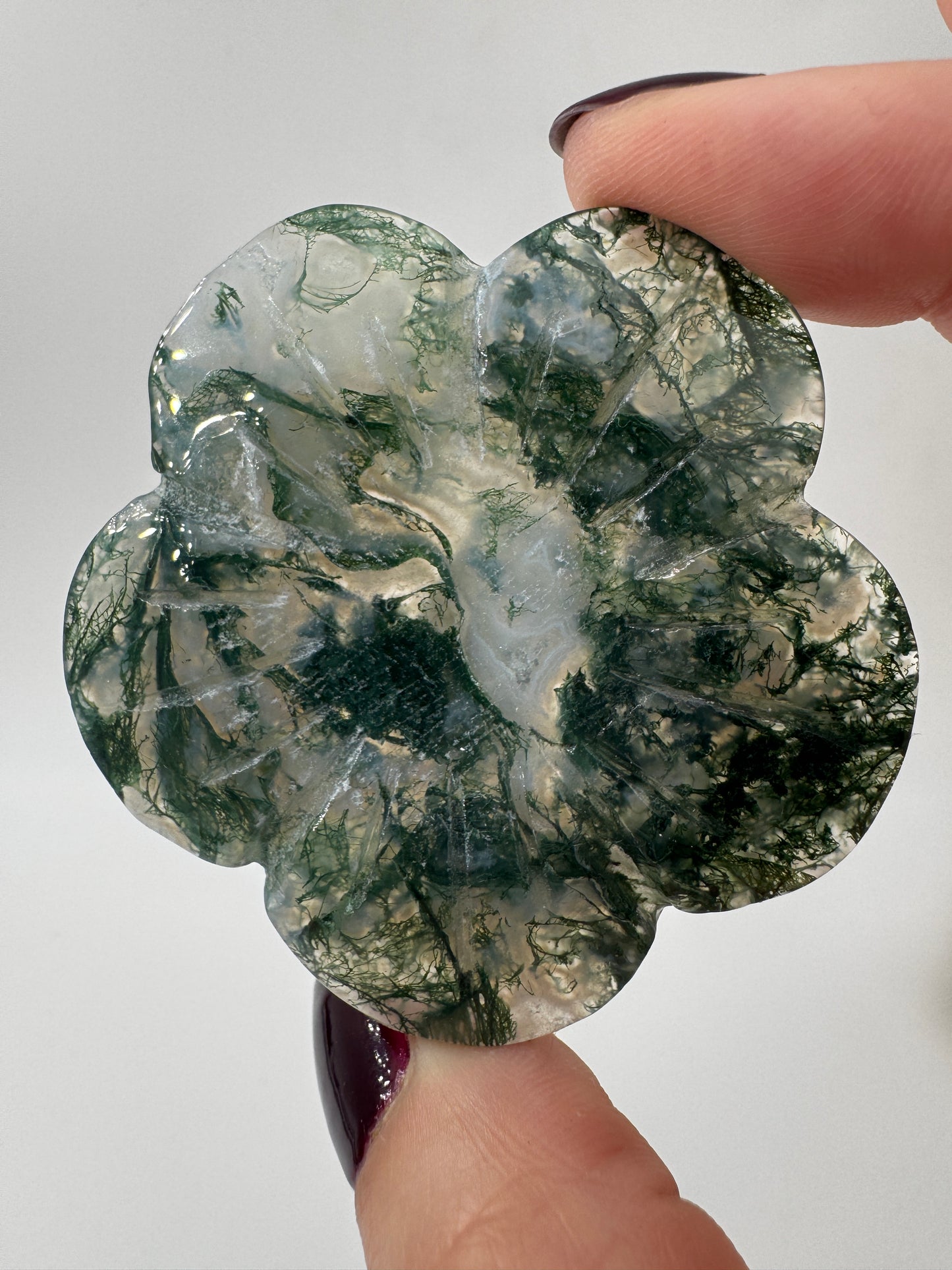 Fein gearbeitetes Blumen-Carving aus Moosachat mit charakteristischer grünlicher Dendritenzeichnung, Durchmesser ca. 5,4 cm, auch als Kugelständer nutzbar.