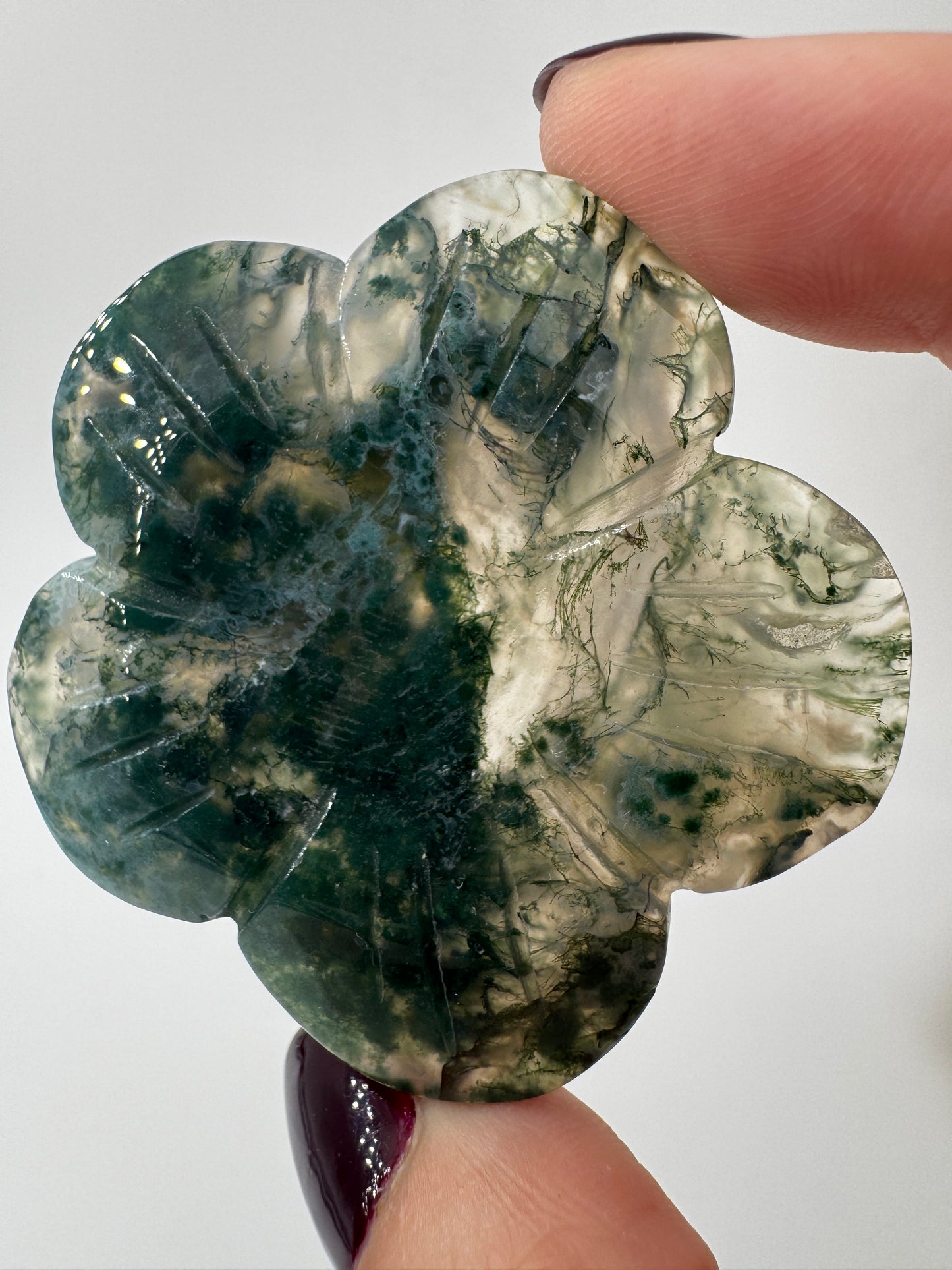 Fein gearbeitetes Blumen-Carving aus Moosachat mit charakteristischer grünlicher Dendritenzeichnung, Durchmesser ca. 5,4 cm, auch als Kugelständer nutzbar.