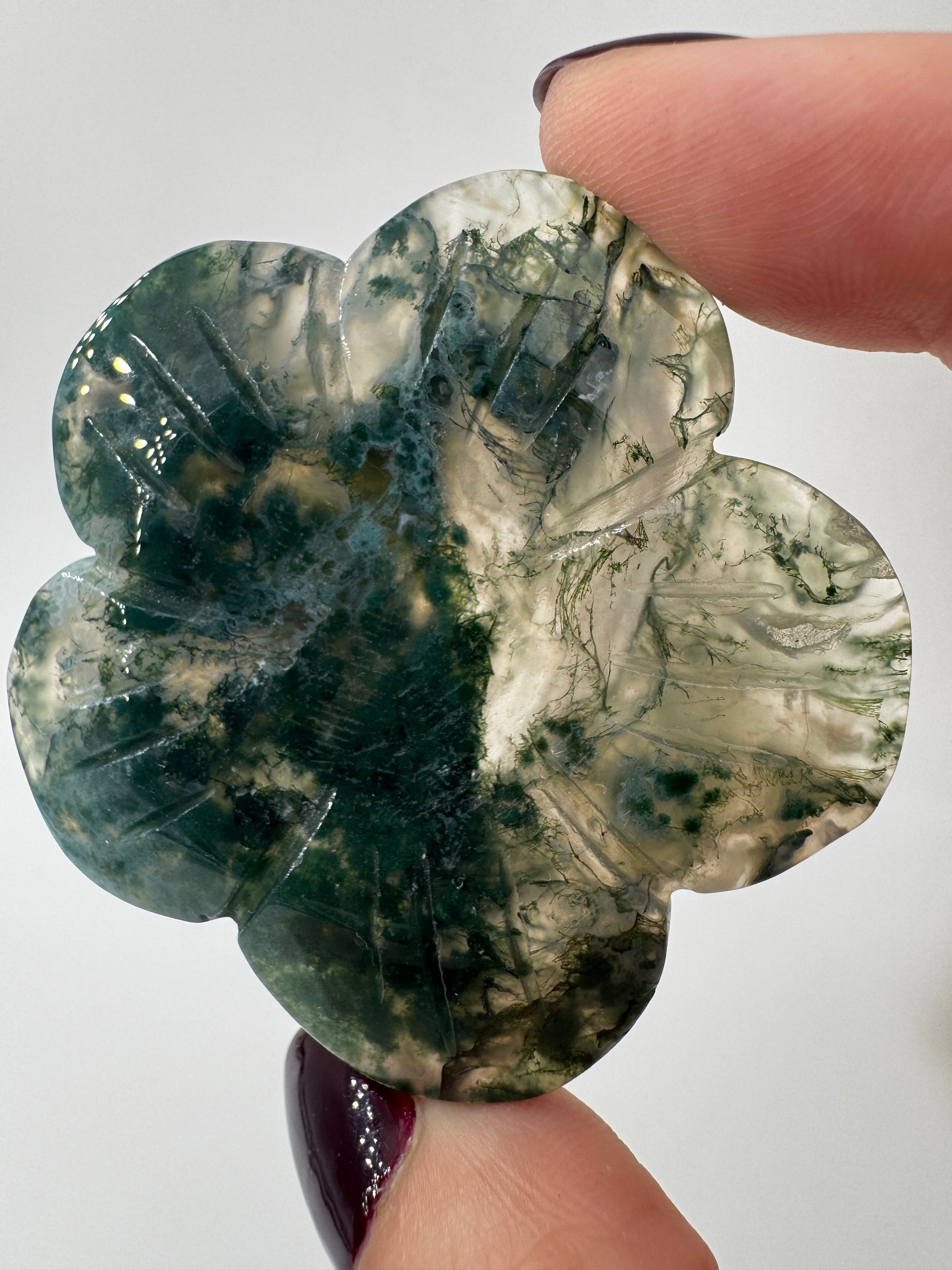 Fein gearbeitetes Blumen-Carving aus Moosachat mit charakteristischer grünlicher Dendritenzeichnung, Durchmesser ca. 5,4 cm, auch als Kugelständer nutzbar.