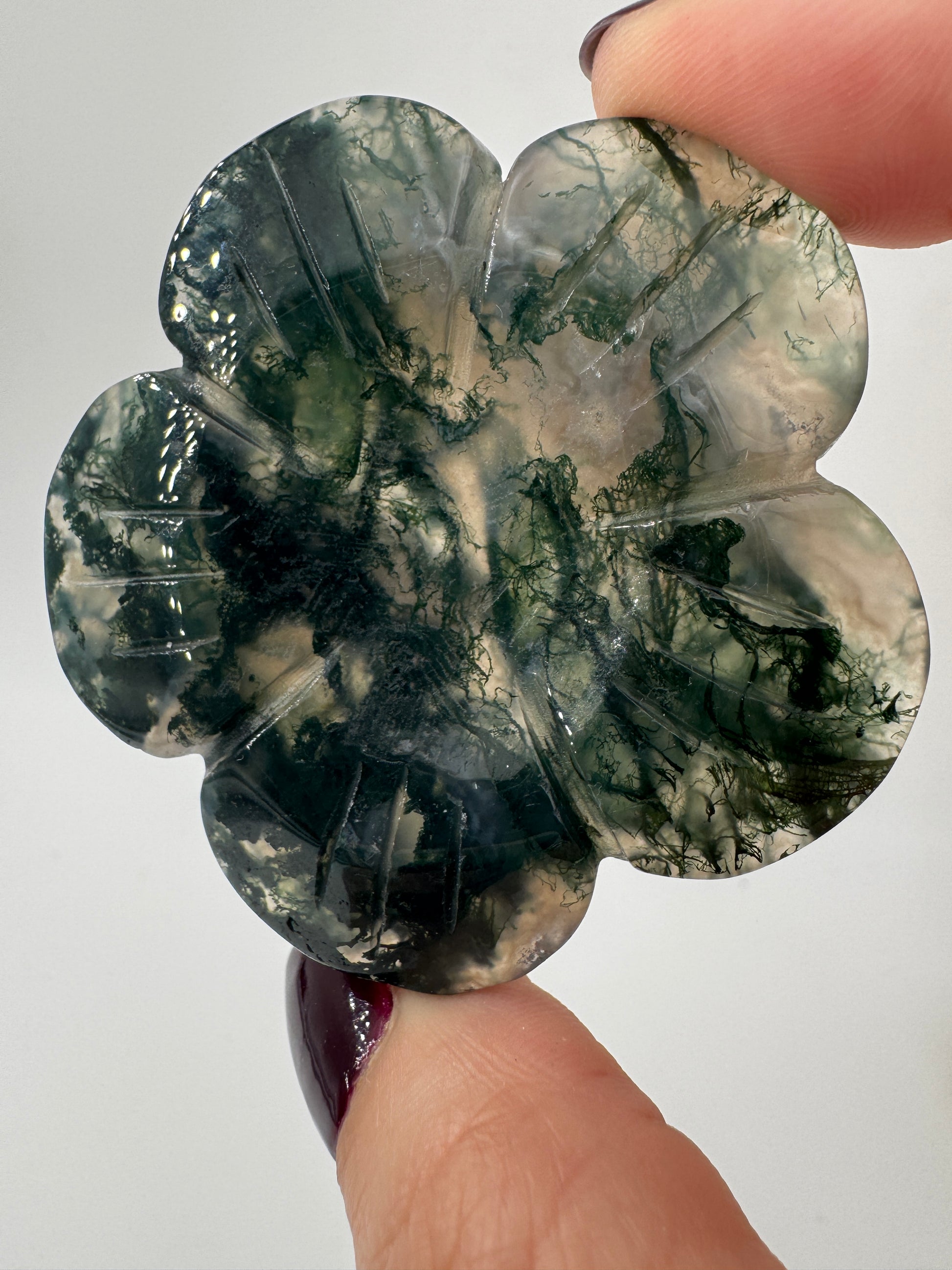 Fein gearbeitetes Blumen-Carving aus Moosachat mit charakteristischer grünlicher Dendritenzeichnung, Durchmesser ca. 5,4 cm, auch als Kugelständer nutzbar.