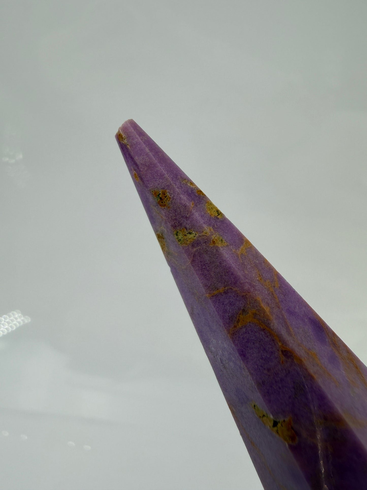 Eine fliederfarbene Phosphosiderit-Stele mit deutlich sichtbarer, natürlicher Bruchstelle an der Spitze und gelben Mineraladern.
