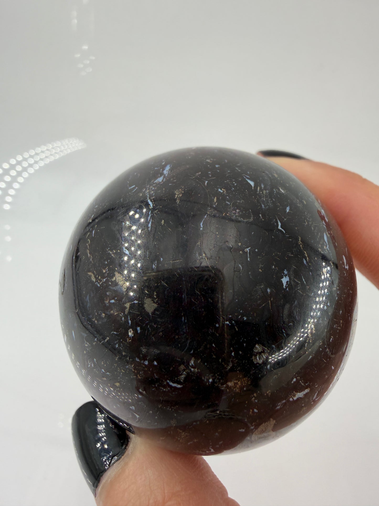 Eine Kugel aus versteinerter Palmenwurzel mit charakteristischem Strukturmuster in wärmenden Erd- und Beigetönen.