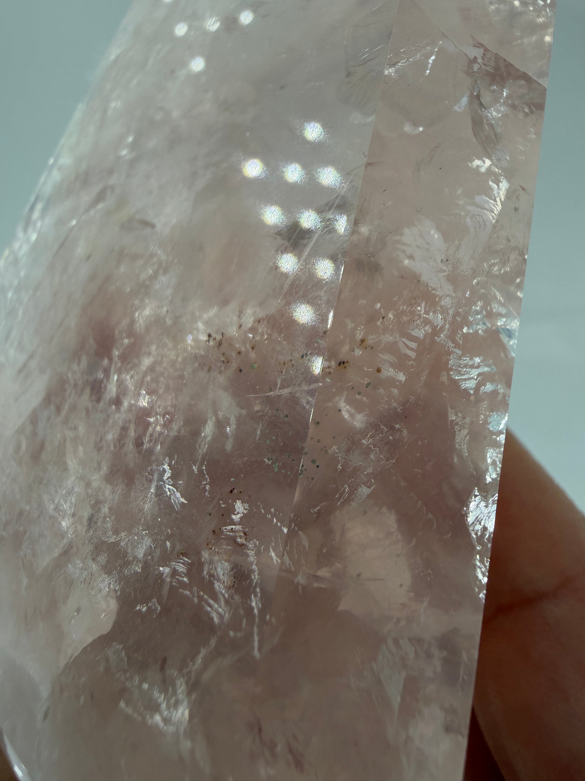 Detailaufnahme einer polierte Rosenquarz-Spitze aus Brasilien mit sanfter rosa Färbung und glänzender Oberfläche.