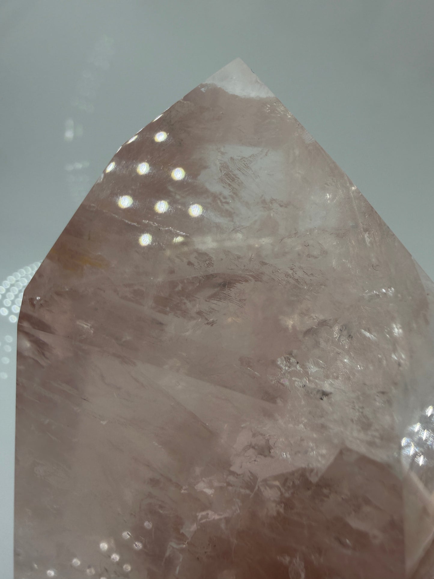 Detailaufnahme einer polierte Rosenquarz-Spitze aus Brasilien mit sanfter rosa Färbung und glänzender Oberfläche.