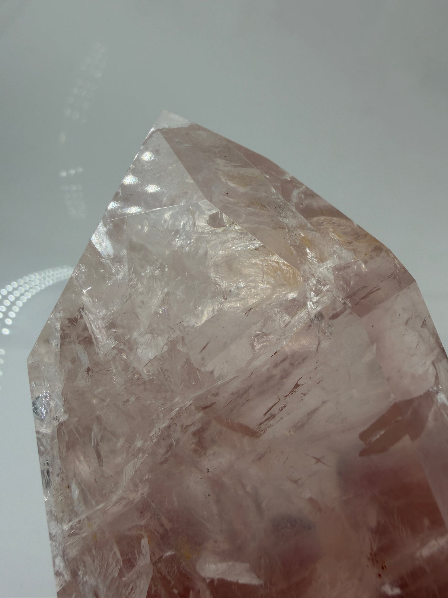 Detailaufnahme einer polierte Rosenquarz-Spitze aus Brasilien mit sanfter rosa Färbung und glänzender Oberfläche.
