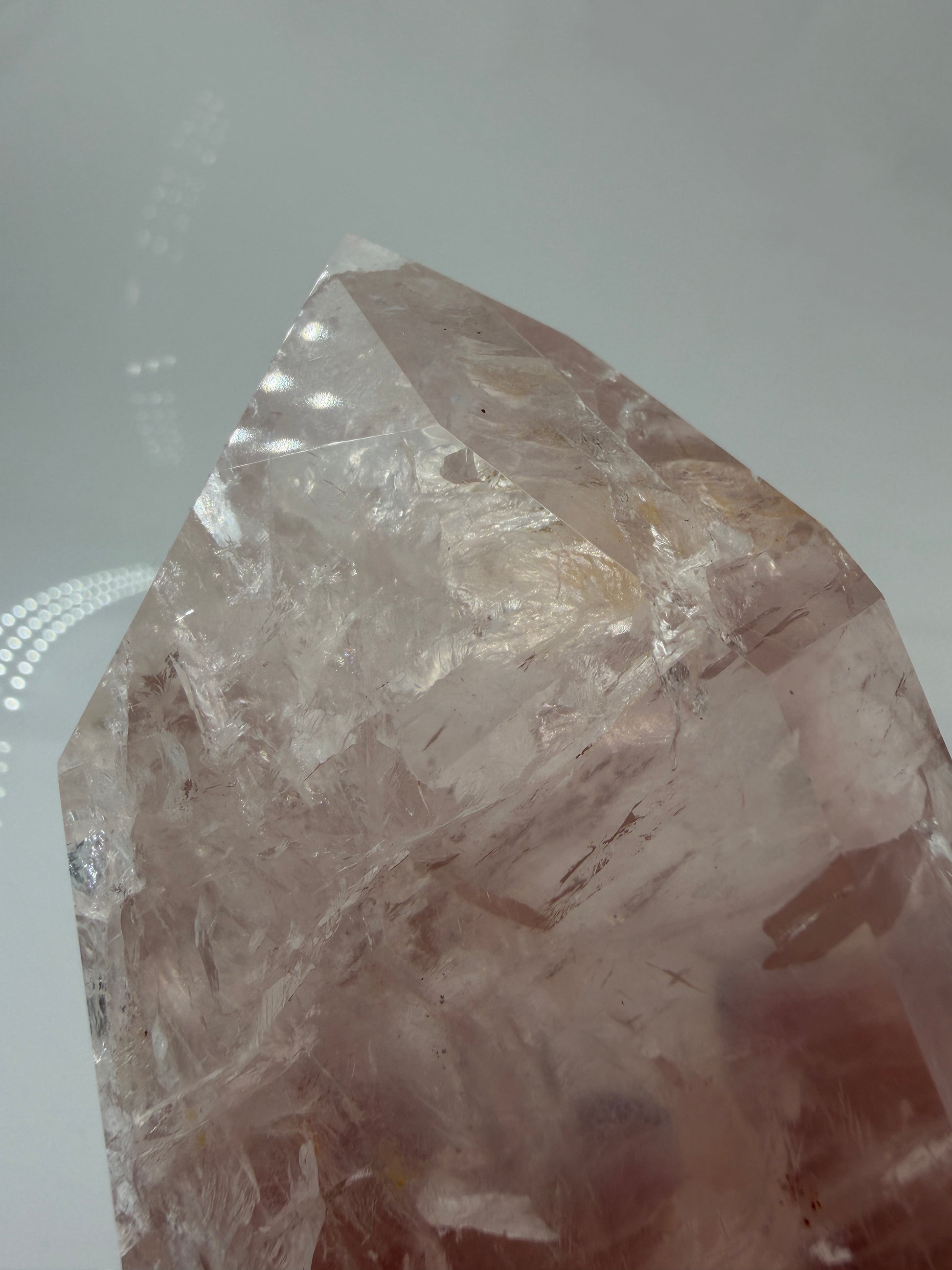 Detailaufnahme einer polierte Rosenquarz-Spitze aus Brasilien mit sanfter rosa Färbung und glänzender Oberfläche.