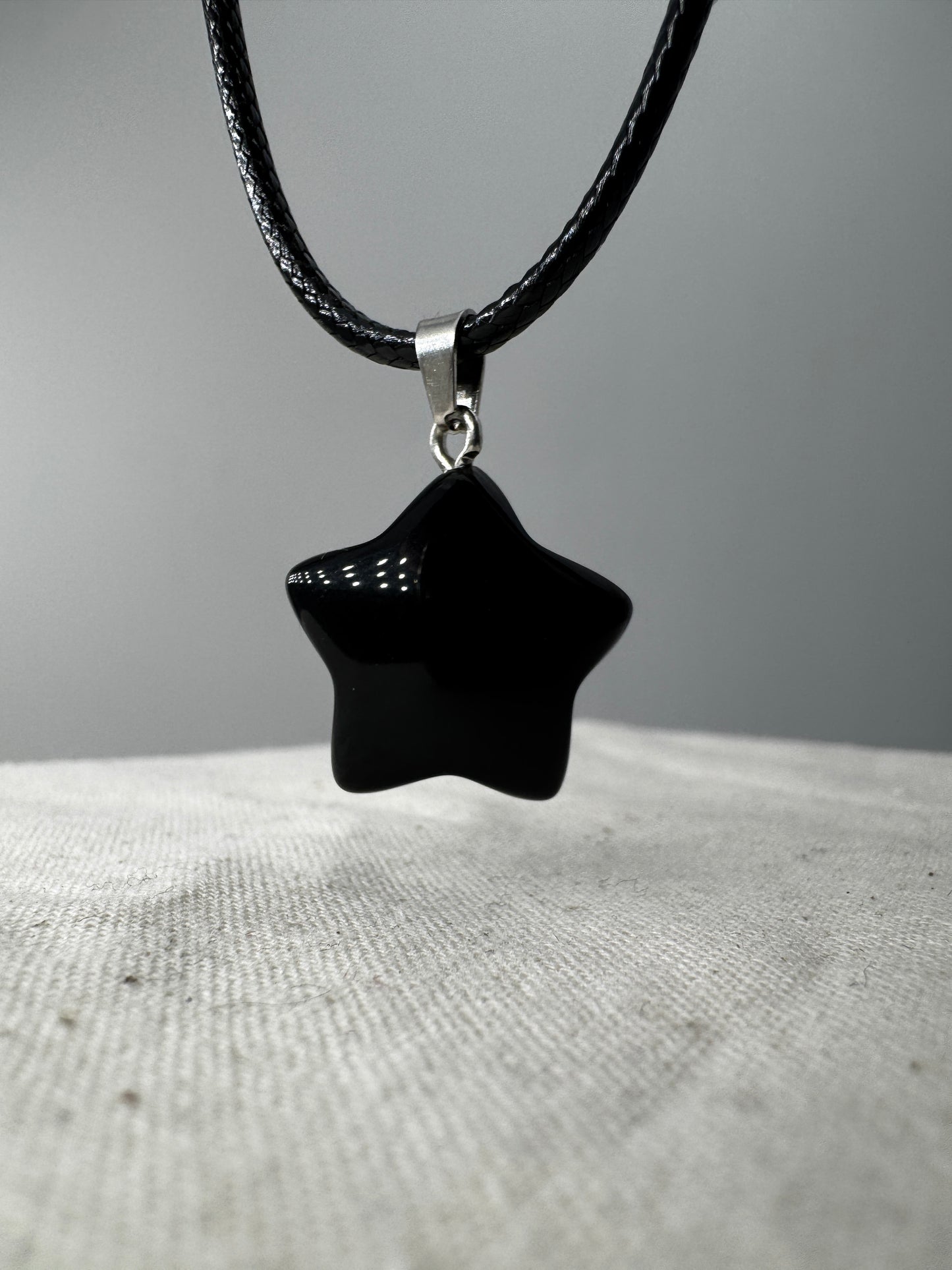 Ein glänzend polierter, tiefschwarzer Obsidian-Anhänger