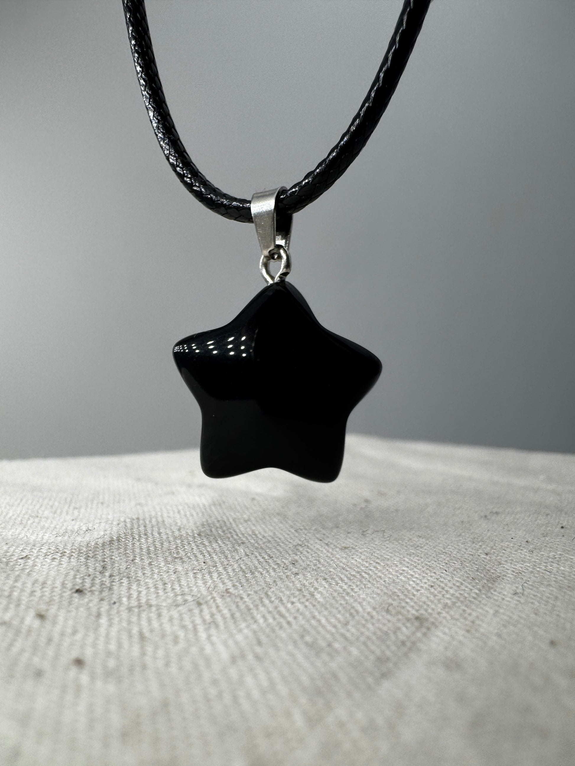 Ein glänzend polierter, tiefschwarzer Obsidian-Anhänger