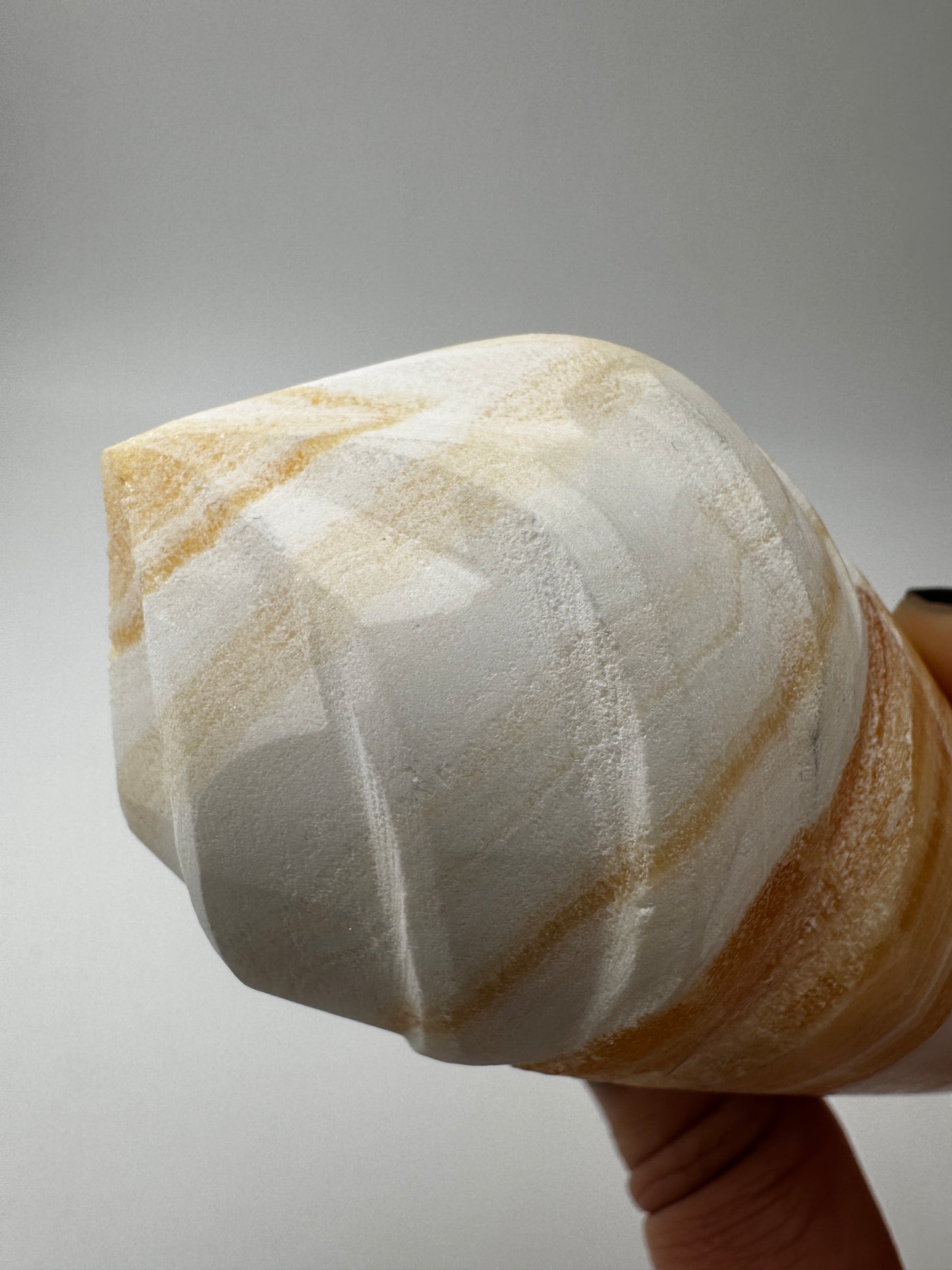 Orangencalcit-Carving OE36 in Softeis-Waffelform mit warmer Transluzenz.