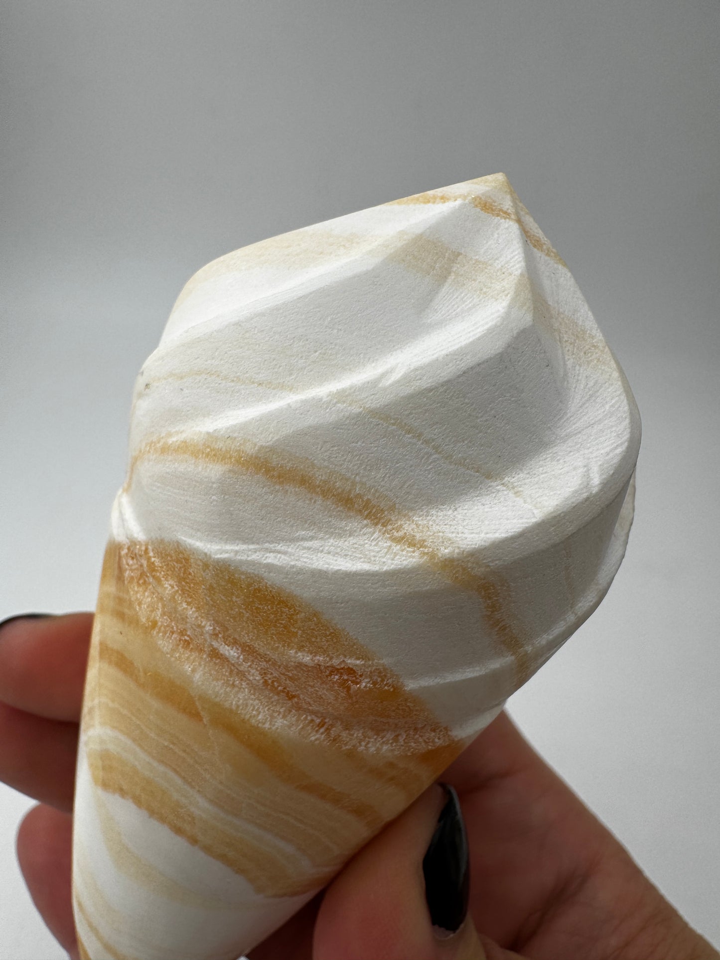 Orangencalcit-Carving OE36 in Softeis-Waffelform mit warmer Transluzenz.