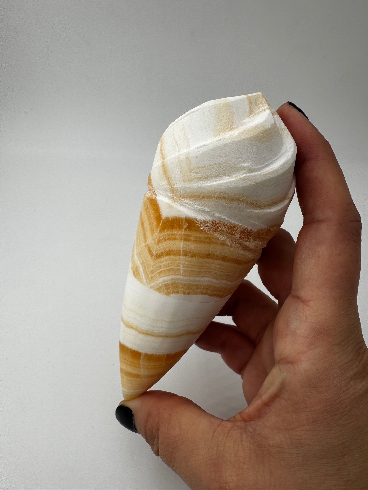 Orangencalcit-Carving OE36 in Softeis-Waffelform mit warmer Transluzenz.