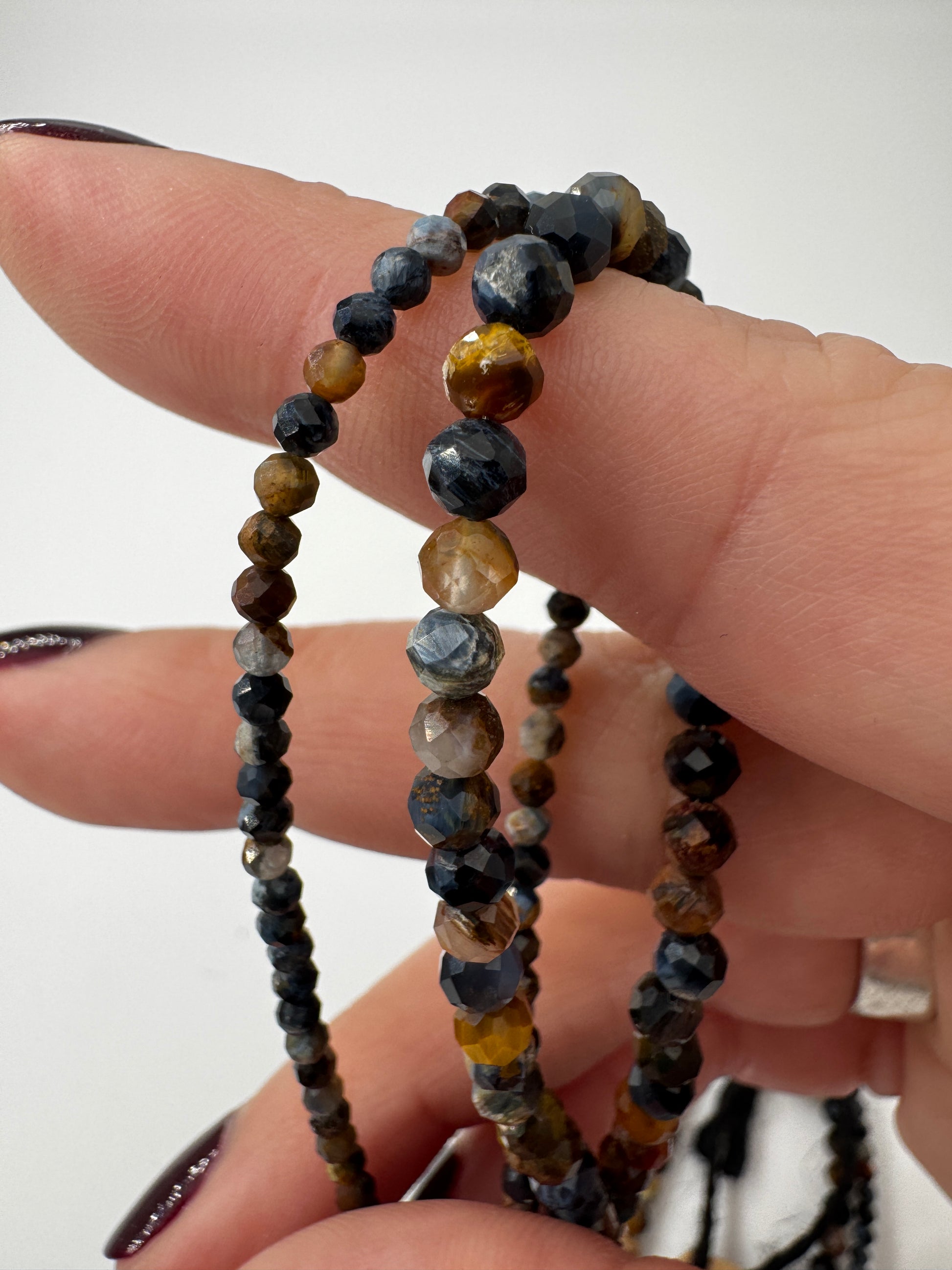 Kette aus facettierten Pietersit-Kugeln mit lebendigem Farbenspiel in Blau, Gold und Braun, erhältlich in 2 mm und 4 mm, 45 cm Länge mit Edelstahlverschluss.