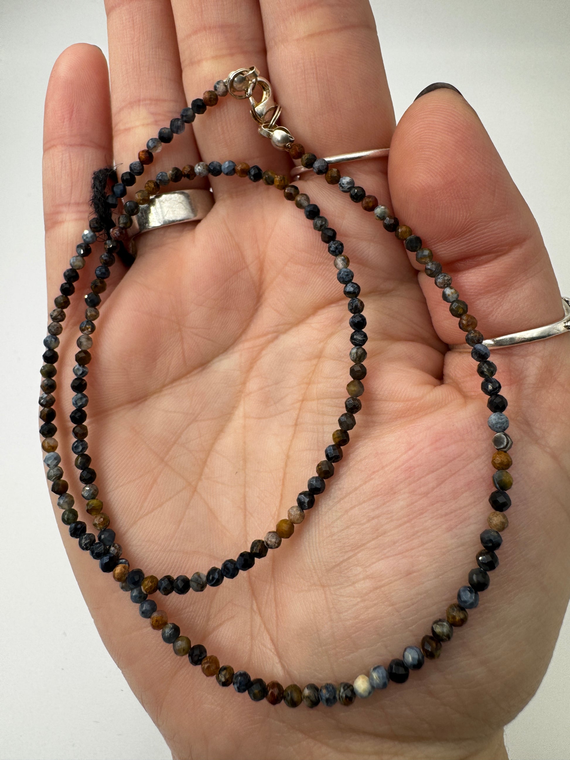 Kette aus facettierten Pietersit-Kugeln mit lebendigem Farbenspiel in Blau, Gold und Braun, erhältlich in 2 mm und 4 mm, 45 cm Länge mit Edelstahlverschluss.