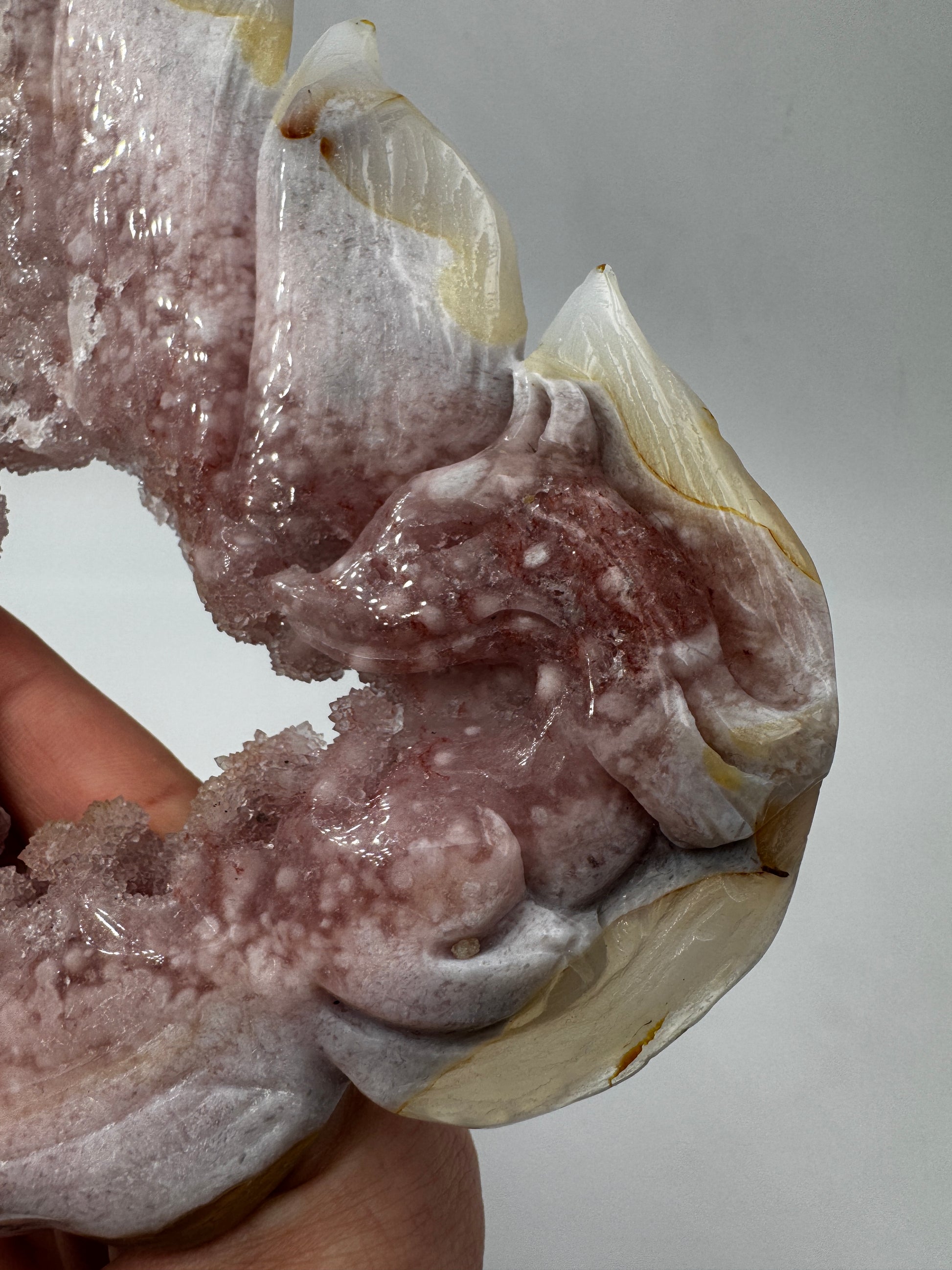 Großformatiges Flachcarving eines neunschwänzigen Fuchses aus pinkem Amethyst AF222 mit charakteristischer Druse und zartrosa Farbgebung inkl. Ständer.