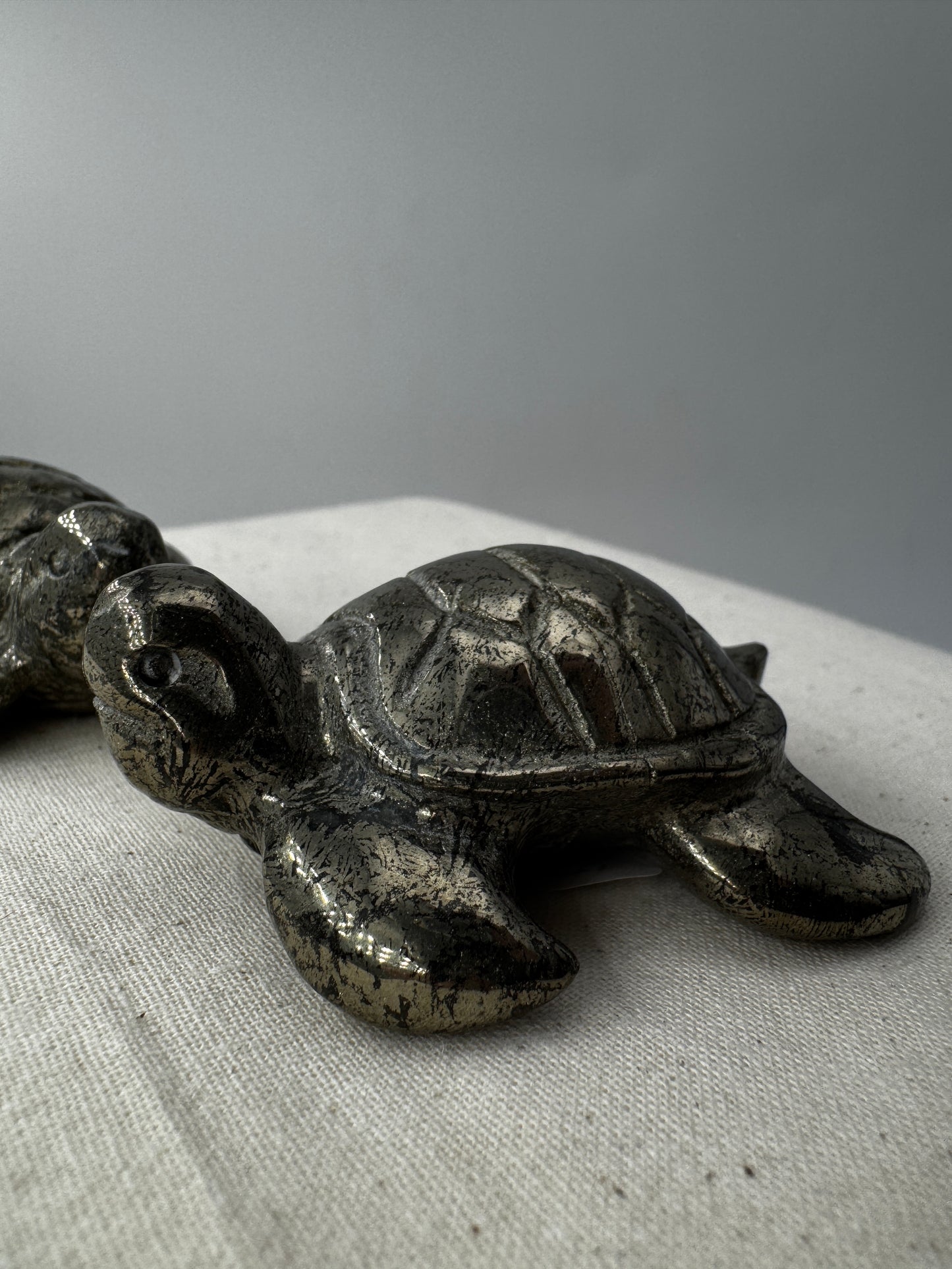 Handgeschliffene Schildkröte aus Pyrit PA19 mit metallischem Glanz.