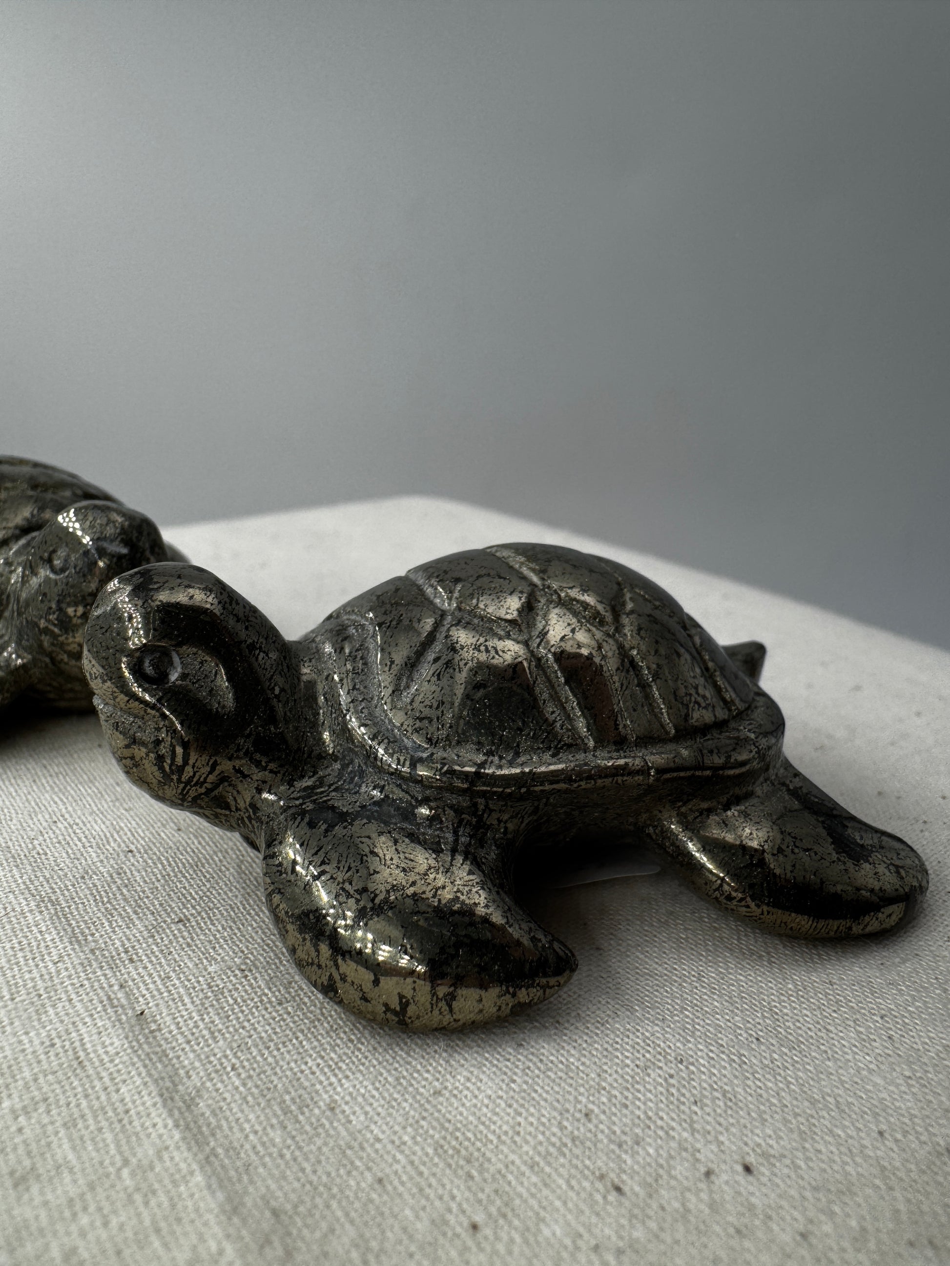 Handgeschliffene Schildkröte aus Pyrit PA19 mit metallischem Glanz.