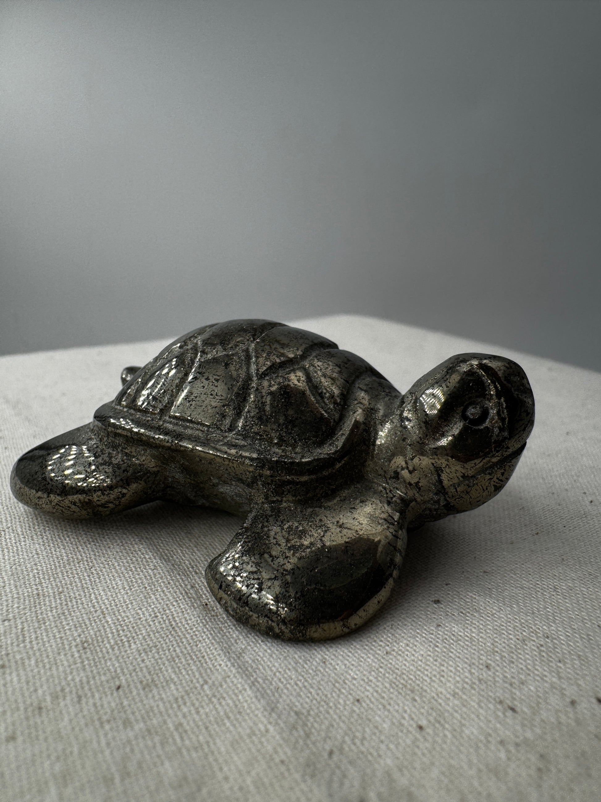 Handgeschliffene Schildkröte aus Pyrit PA19 mit metallischem Glanz.