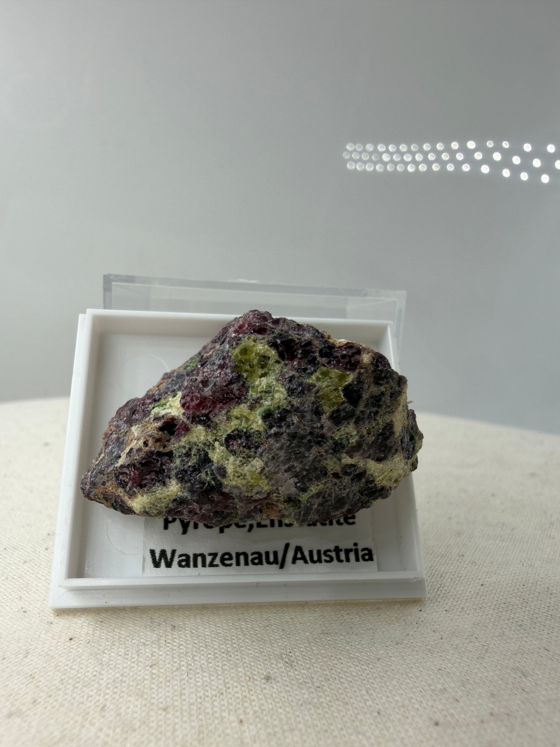 Mineral-Cluster aus Pyrop-Granat und Enstatit aus der Wanzenau, Österreich, in charakteristischer Matrix.