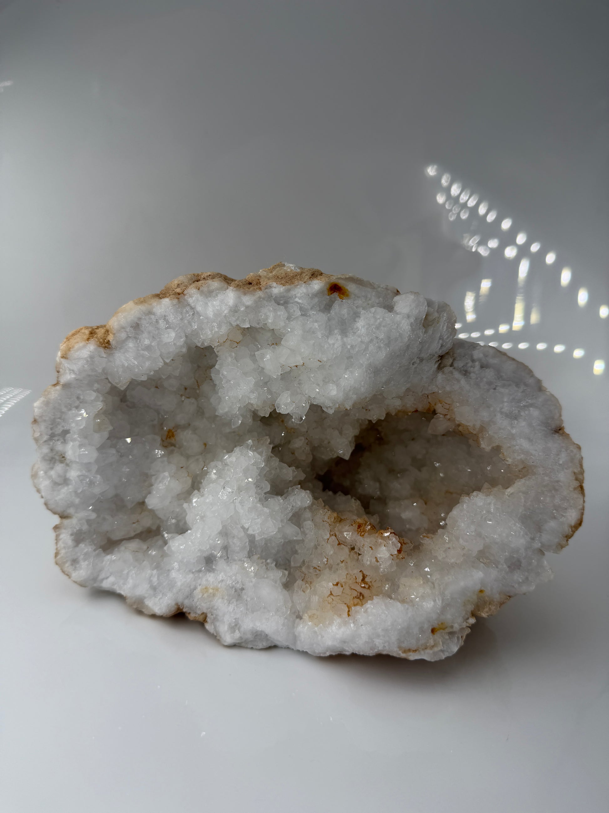 Offene Quarzgeode mit zahlreichen, klar terminierten Bergkristall-Spitzen im Inneren eines Gesteinshohlraums.