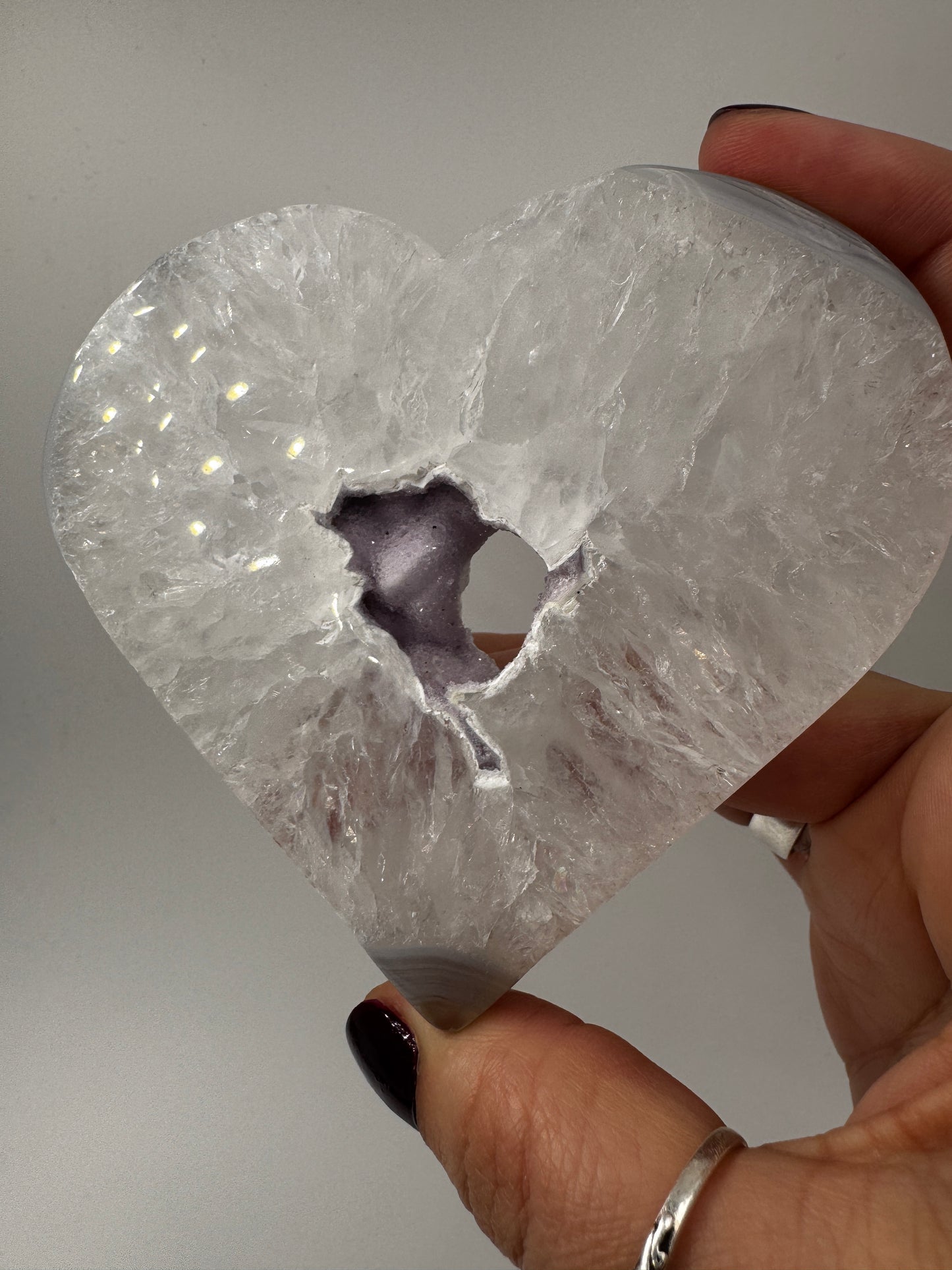 Großformatiges herzförmiges Carving aus milchigem Quarz und gebändertem Achat mit kleiner lila Druse.