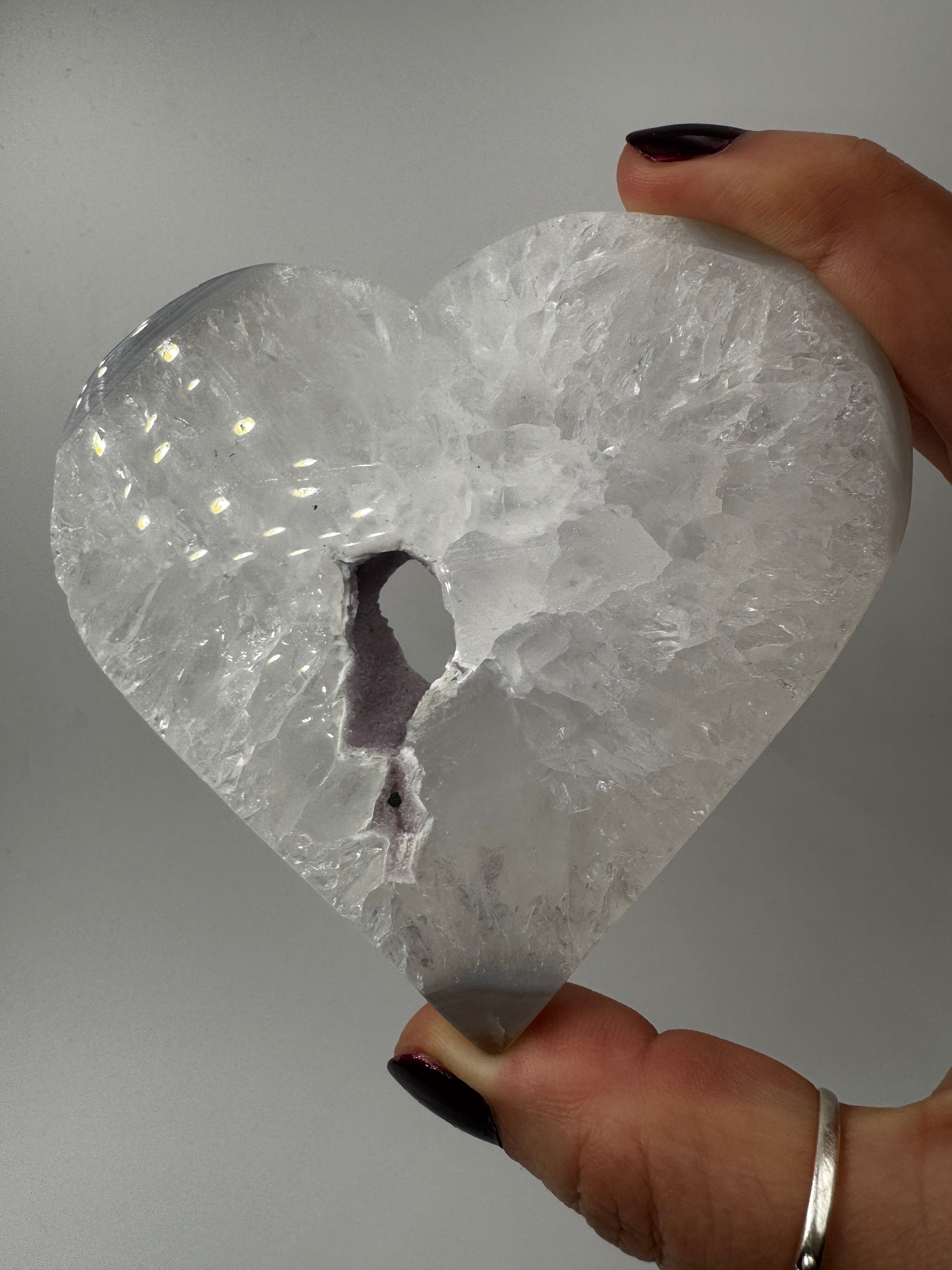 Großformatiges herzförmiges Carving aus milchigem Quarz und gebändertem Achat mit kleiner lila Druse.