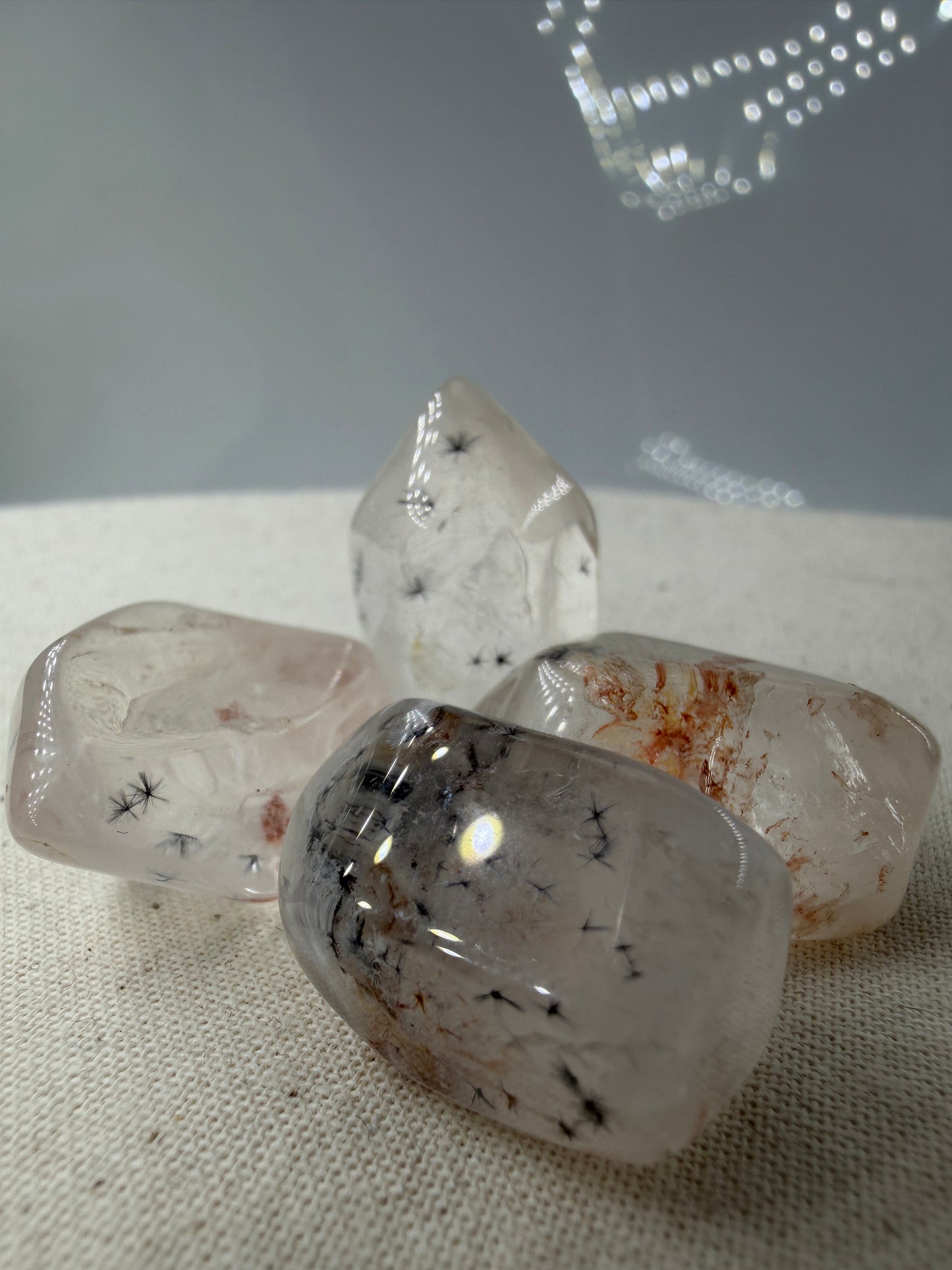 Hollandit mit Quarz: schwarze, nadelförmige Hollandit-Einschlüsse in klarem bis milchigem Quarz, geschliffen, ca. 1,5–3 cm – Qualität B