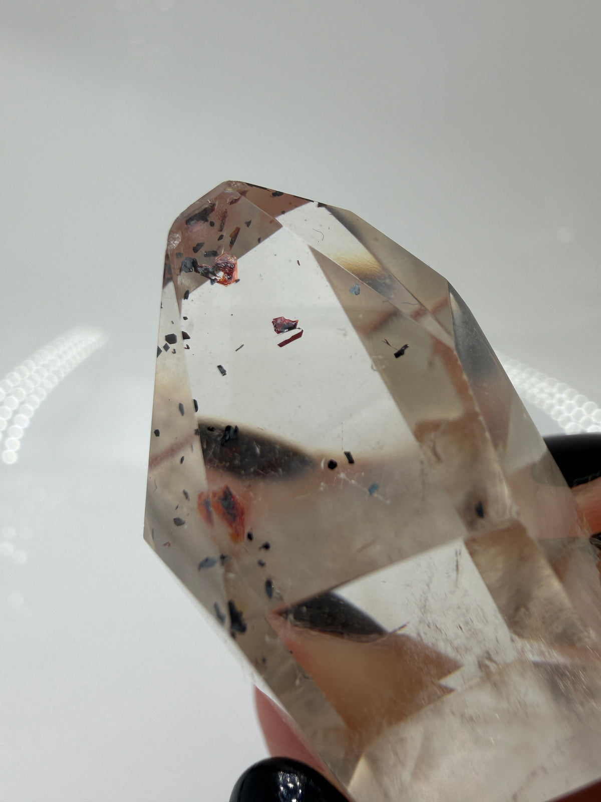 Quarz Spitze mit Hämatit-Plättchen QH12, 3,5 cm Höhe, mit silbrig glänzenden Hämatit-Einschlüssen im transparenten Quarz.