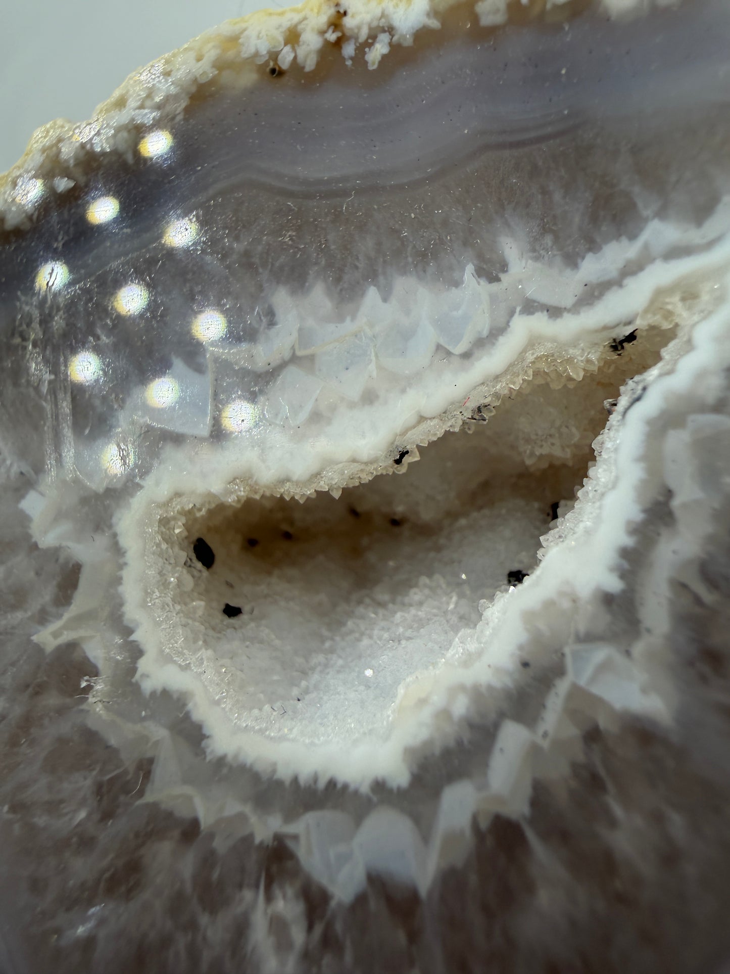 Detailansicht der kristallinen Quarzdruse im Inneren einer Achatgeode, zeigt terminierte Bergkristall-Spitzen.