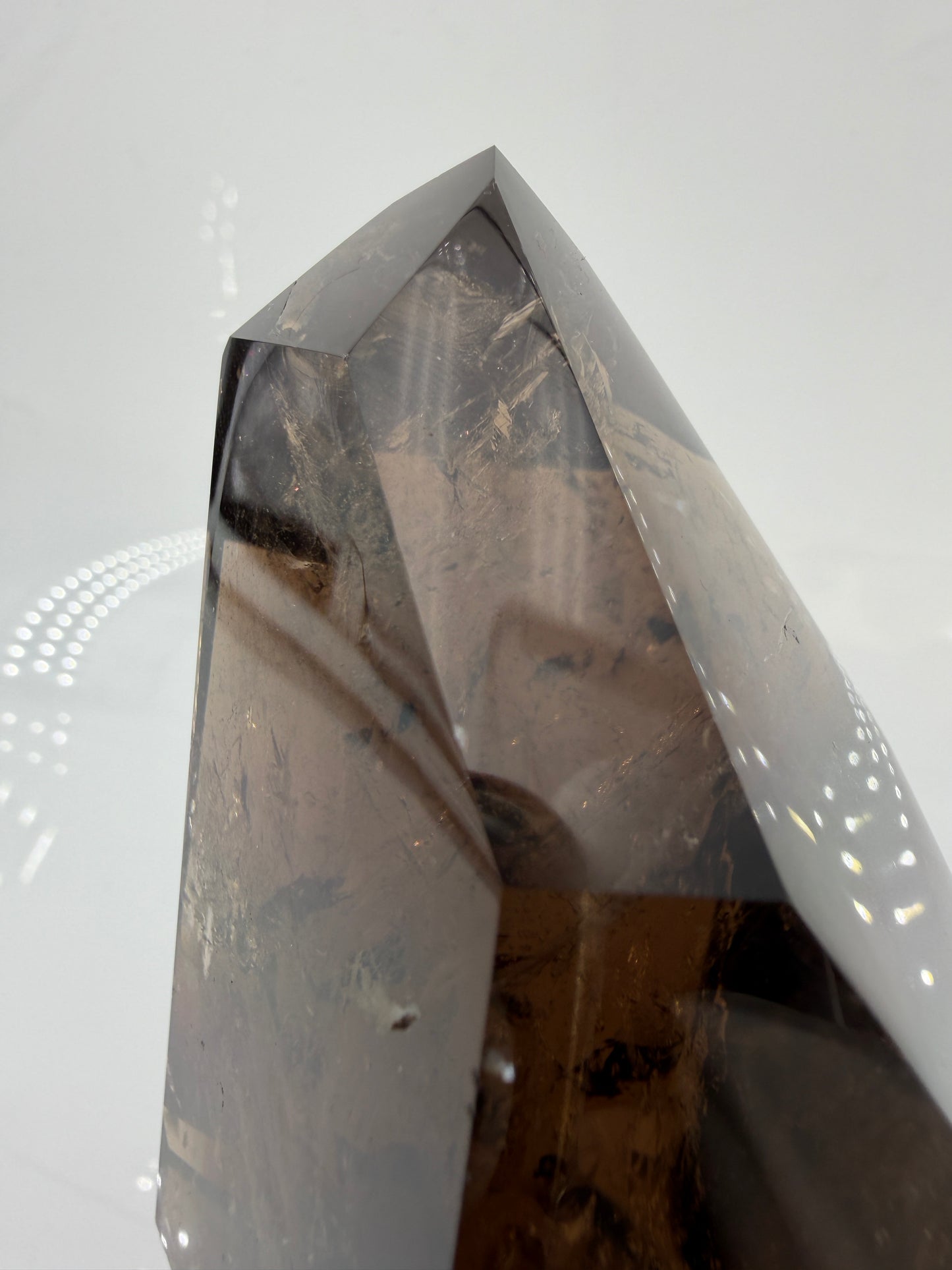 Natürliche Rauchquarz-Spitze aus Brasilien mit brauner Färbung und sichtbaren Kantenmerkmalen.