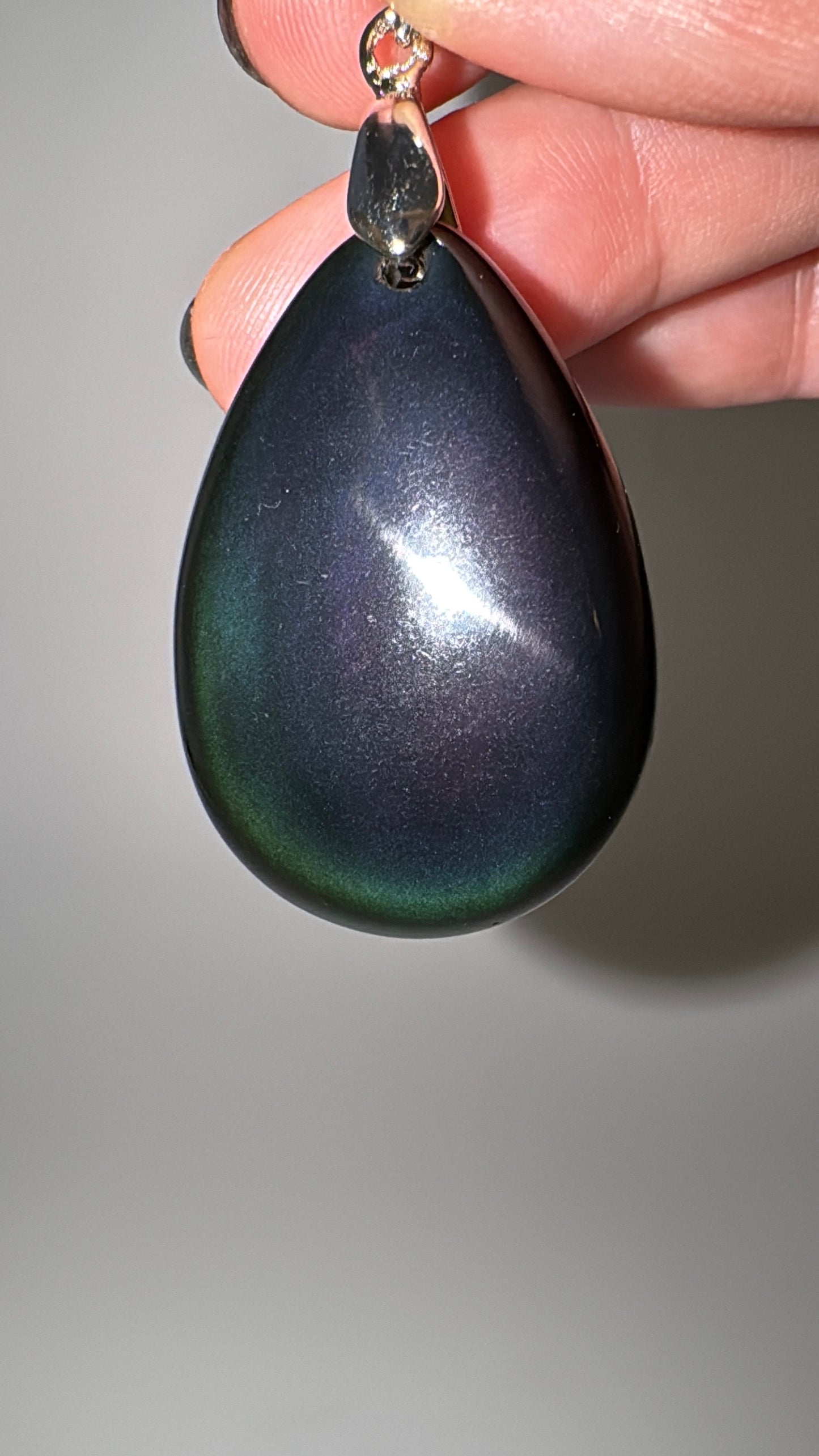Anhänger aus Regenbogen-Obsidian mit schillerndem Farbenspiel.