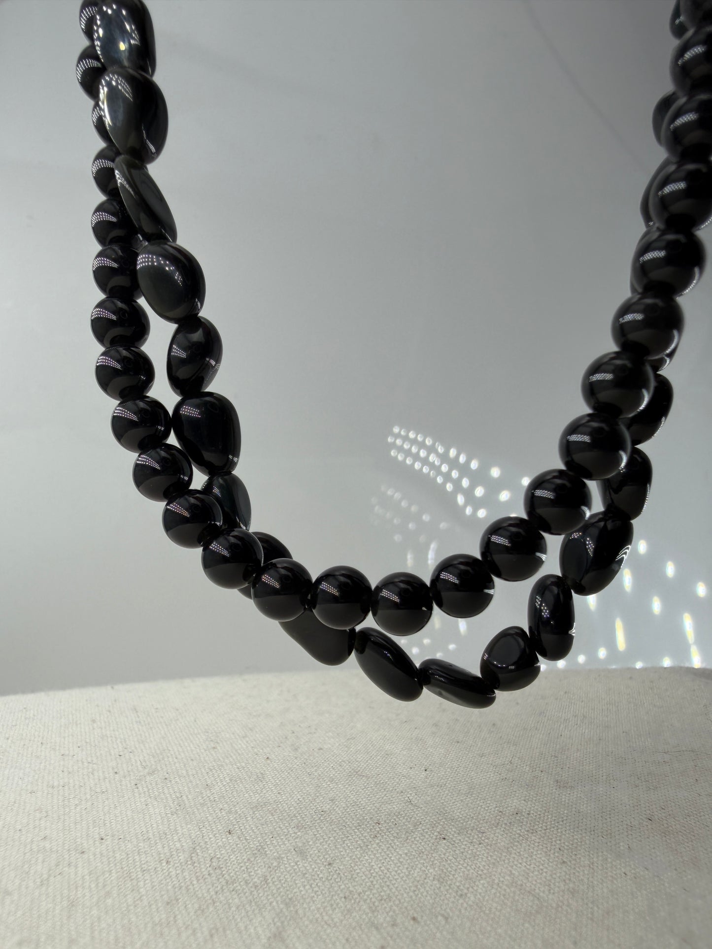 Regenbogenobsidian Kette, 45 cm, mit gleichmäßig geschliffenen 6,6-mm-Perlen oder mit organisch geformten Nuggets aus irisierendem Vulkanglas und Edelstahlverschluss.