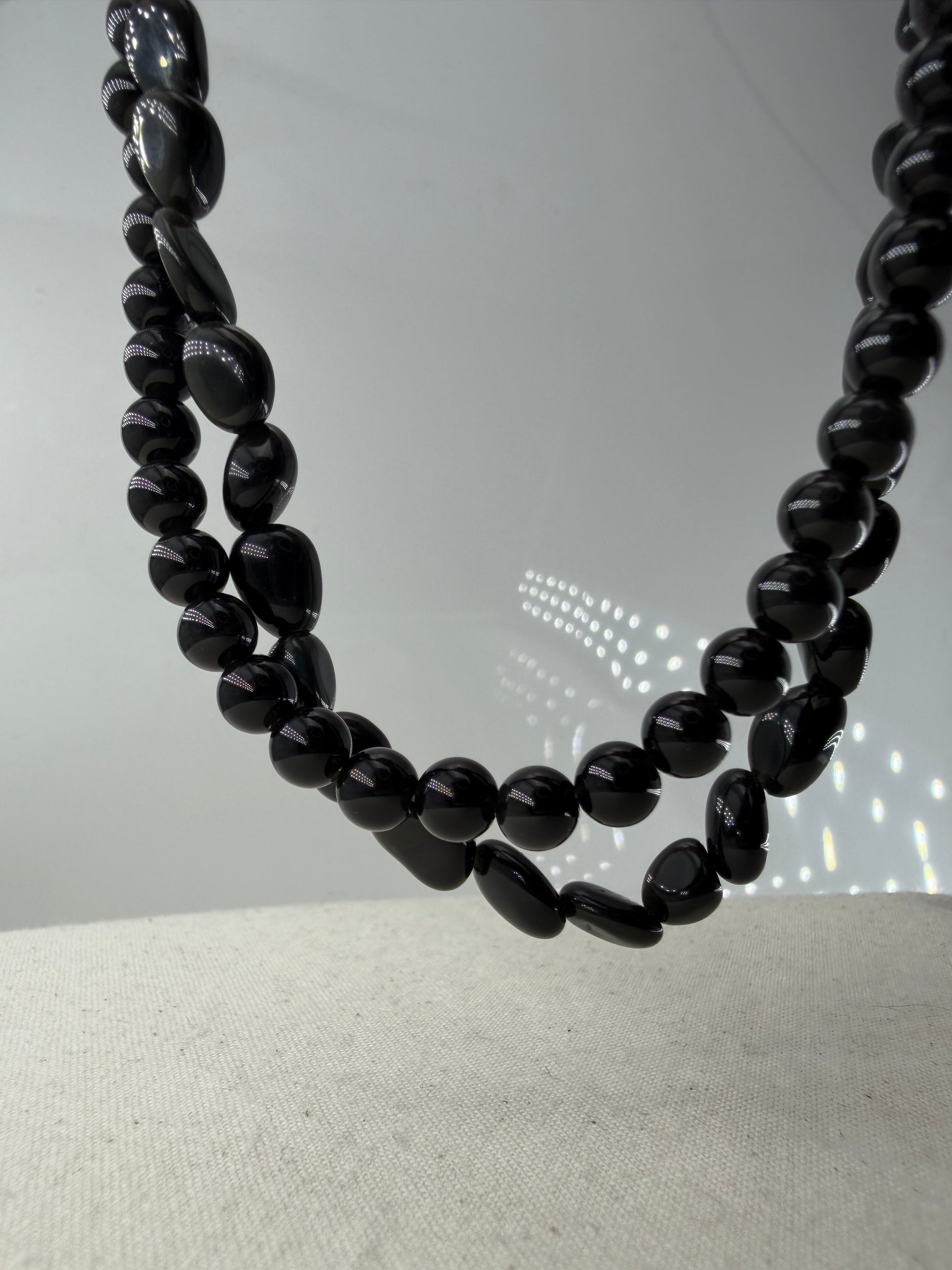 Regenbogenobsidian Kette, 45 cm, mit gleichmäßig geschliffenen 6,6-mm-Perlen oder mit organisch geformten Nuggets aus irisierendem Vulkanglas und Edelstahlverschluss.
