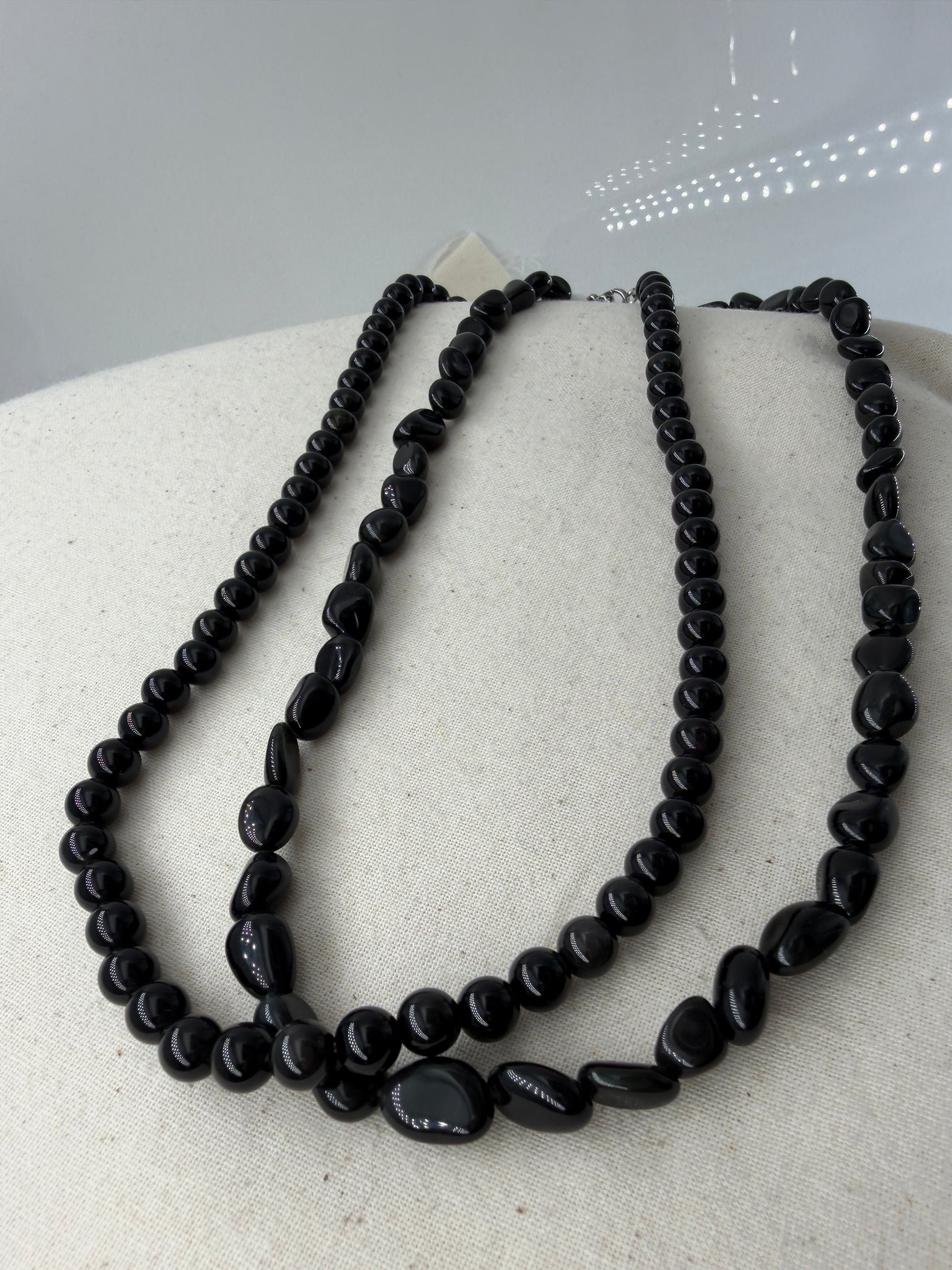 Regenbogenobsidian Kette, 45 cm, mit gleichmäßig geschliffenen 6,6-mm-Perlen oder mit organisch geformten Nuggets aus irisierendem Vulkanglas und Edelstahlverschluss.