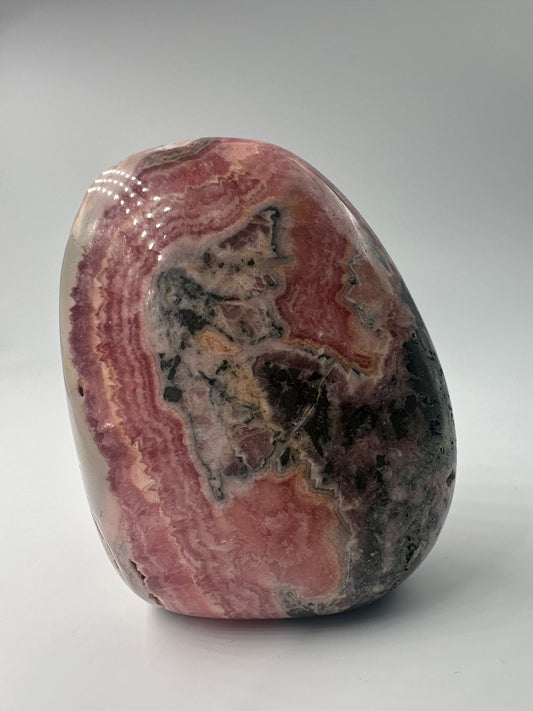 Rhodochrosit Freiform RFC180, 6×4,6 cm, poliert, mit charakteristischer konzentrischer Rosarosa-Bänderung 
