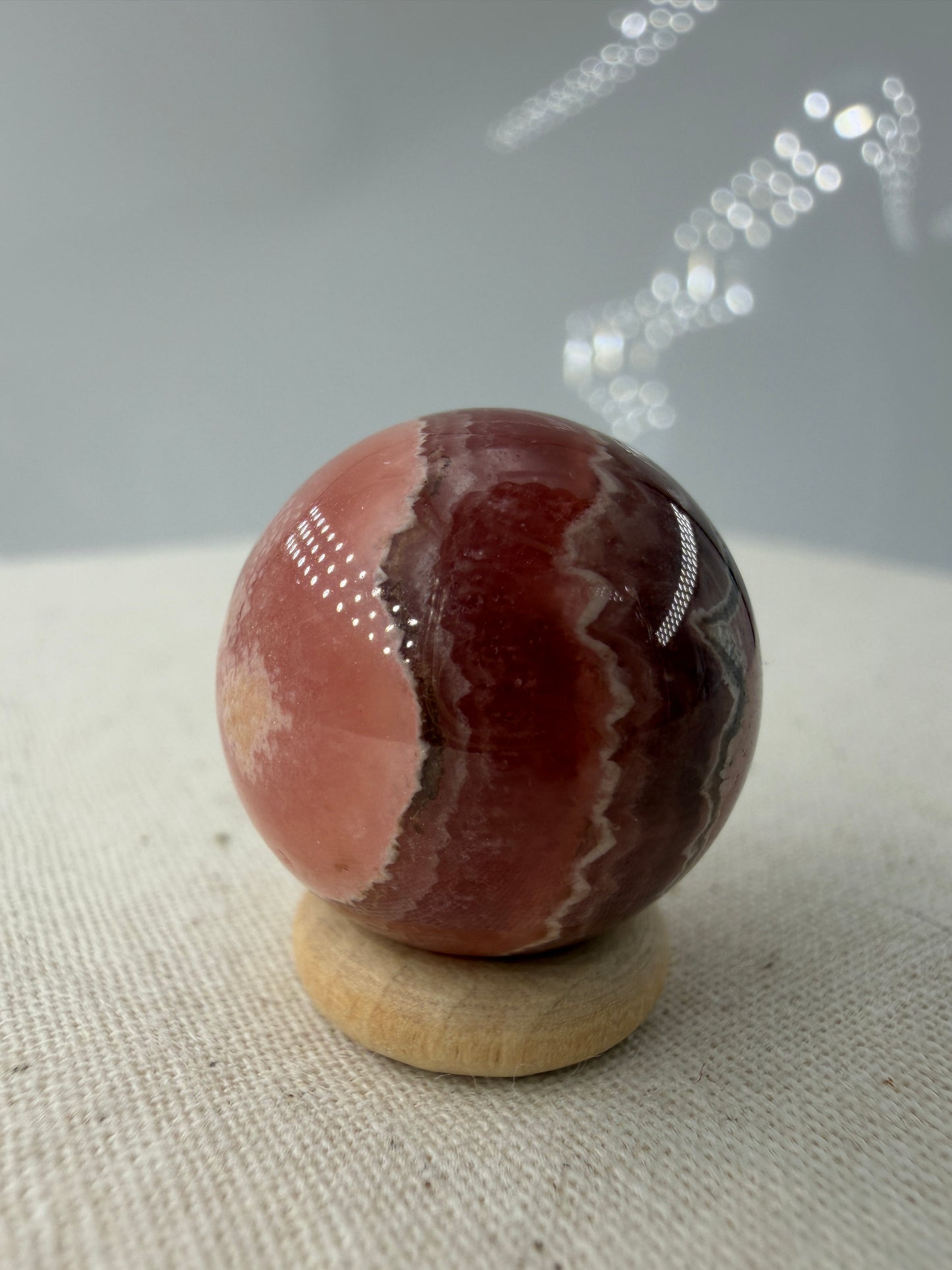 Polierte Kugel aus Rhodochrosit mit leuchtend rosa konzentrischen Bändern, Durchmesser 1,9 cm.
