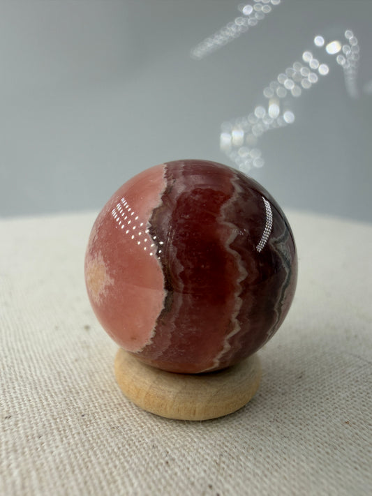 Polierte Kugel aus Rhodochrosit mit leuchtend rosa konzentrischen Bändern, Durchmesser 1,9 cm.