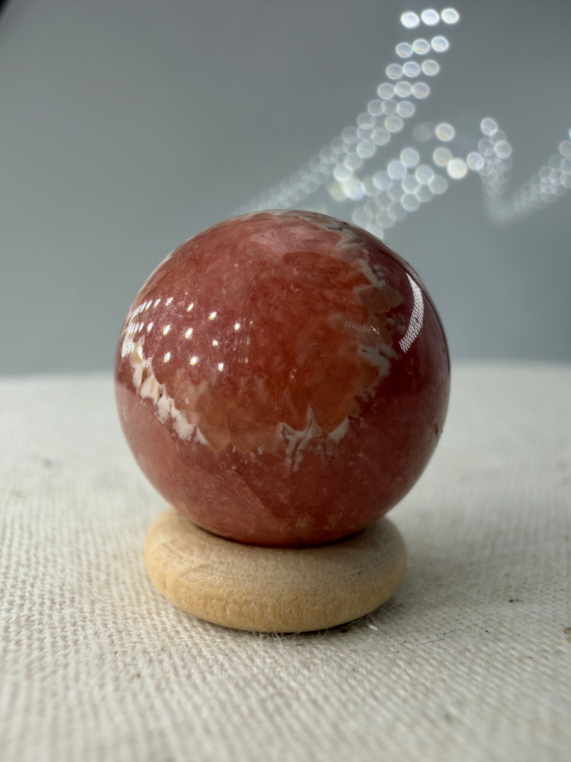 Polierte Kugel aus Rhodochrosit mit leuchtend rosa konzentrischen Bändern, Durchmesser 1,7cm.