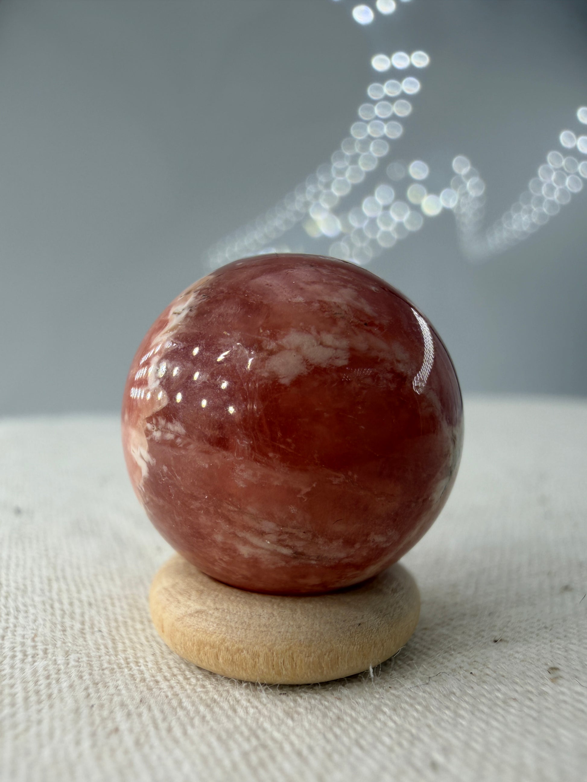 Polierte Kugel aus Rhodochrosit mit leuchtend rosa konzentrischen Bändern, Durchmesser 1,7cm.