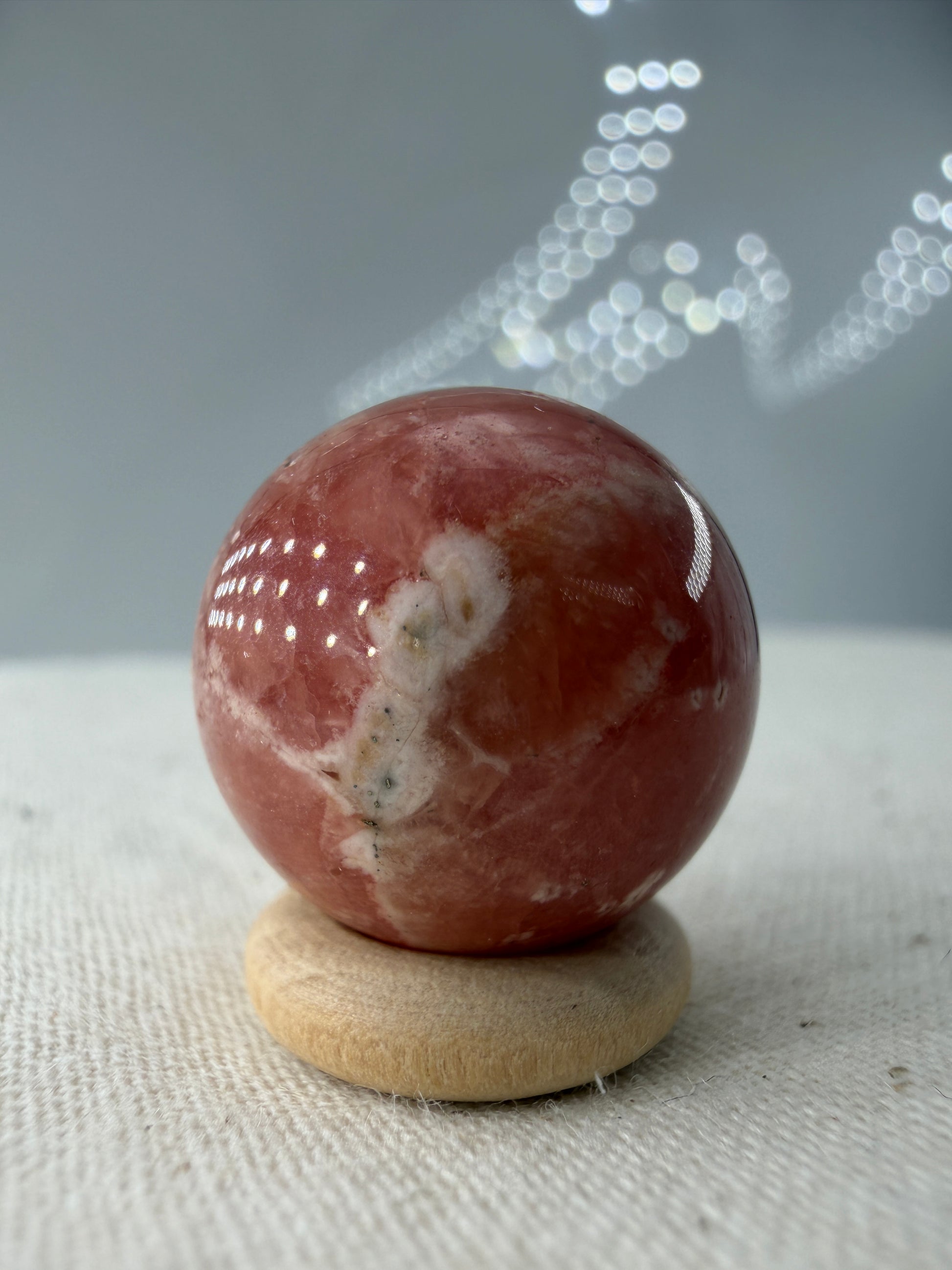 Polierte Kugel aus Rhodochrosit mit leuchtend rosa konzentrischen Bändern, Durchmesser 1,7cm.