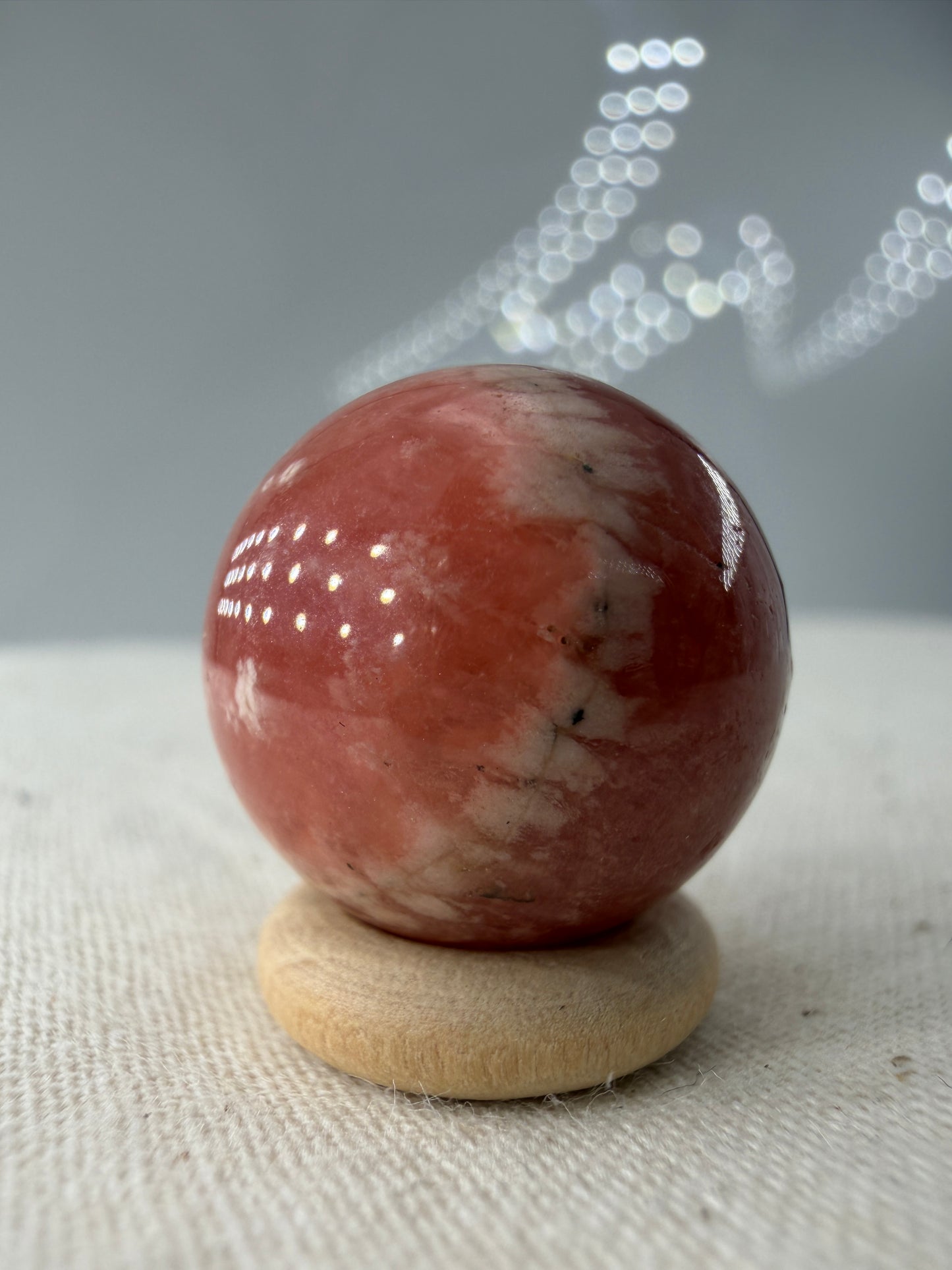 Polierte Kugel aus Rhodochrosit mit leuchtend rosa konzentrischen Bändern, Durchmesser 1,7cm.