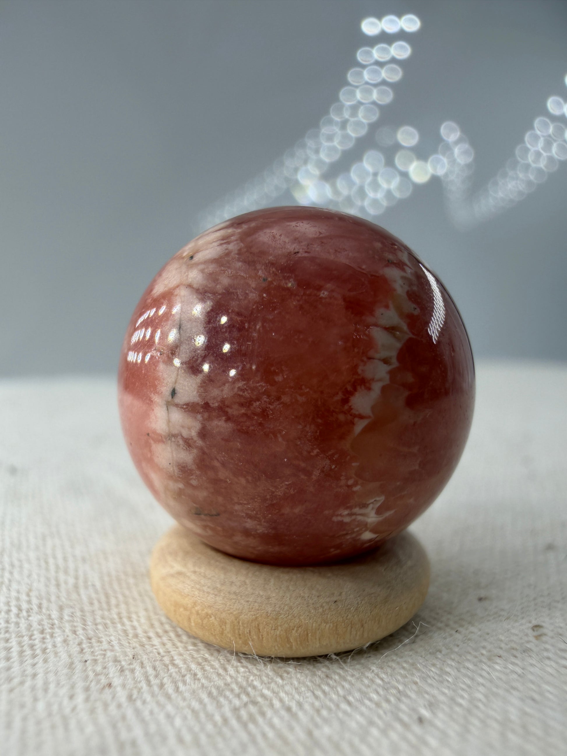 Polierte Kugel aus Rhodochrosit mit leuchtend rosa konzentrischen Bändern, Durchmesser 1,7cm.