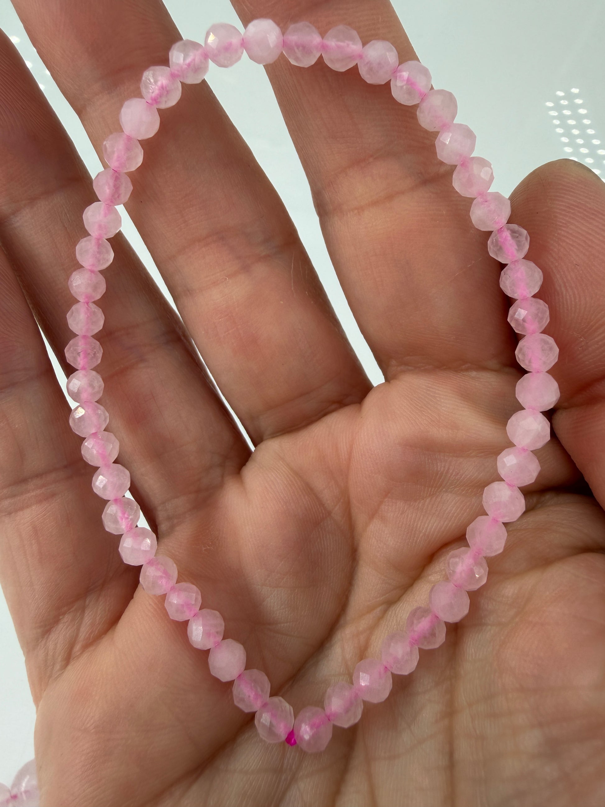 Elastisches Kugelarmband mit facettierten Kugeln aus Rosenquarz mit einem natürlichen Rosa.